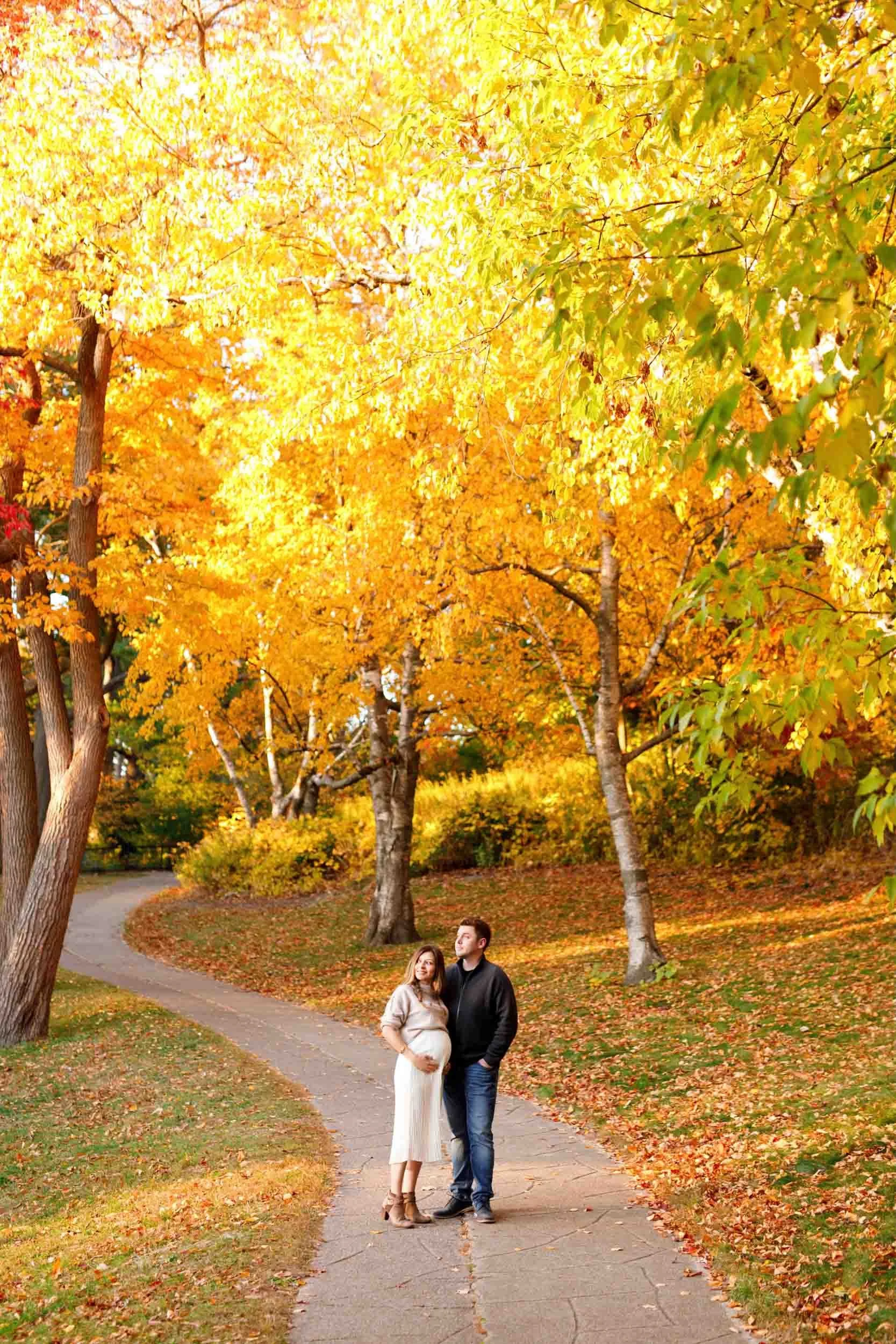 Expectant couple walking through fall foliage during a High Park maternity session (Copy)