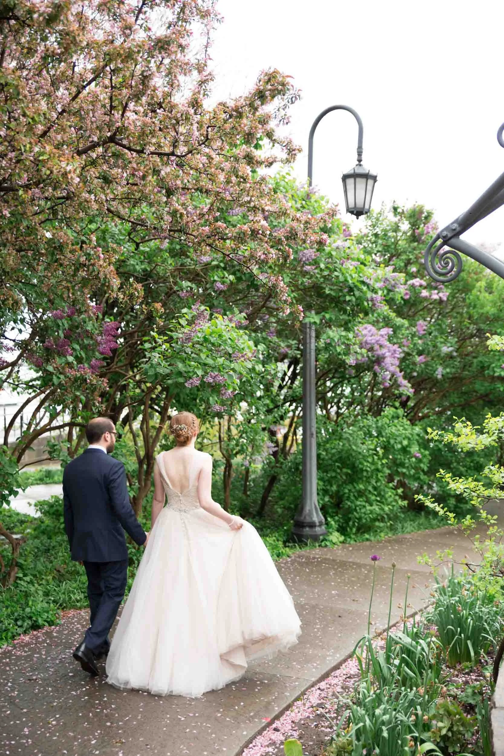 Bride and groom walking together through the Toronto Music Garden along Lakeshore (Copy)
