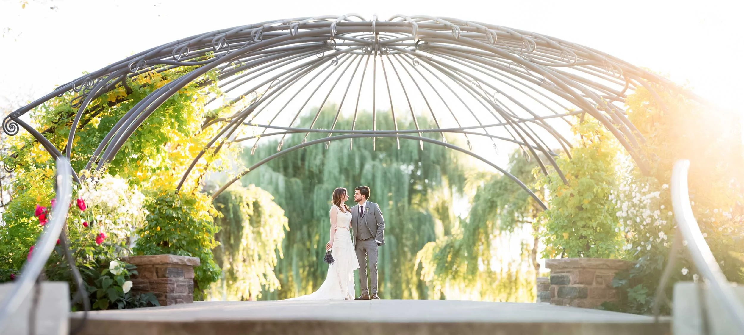 Wedding couple framed by greenery and metal arches at the Toronto Music Garden (Copy)