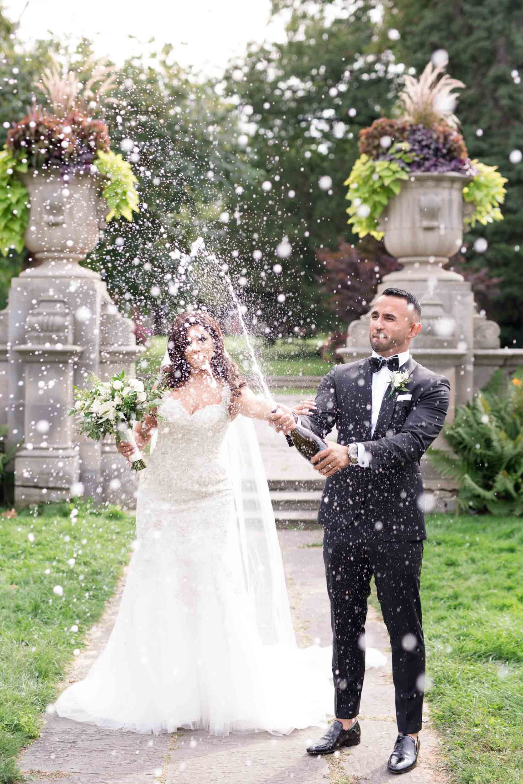 Bride and groom celebrating with a champagne spray during a wedding at Glendon Hall in Toronto (Copy)