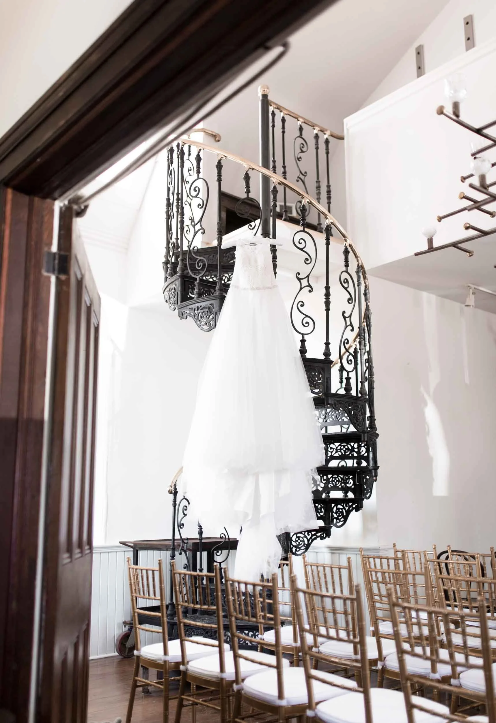 Wedding dress hanging from a spiral iron staircase at a Greater Toronto Area wedding venue (Copy)