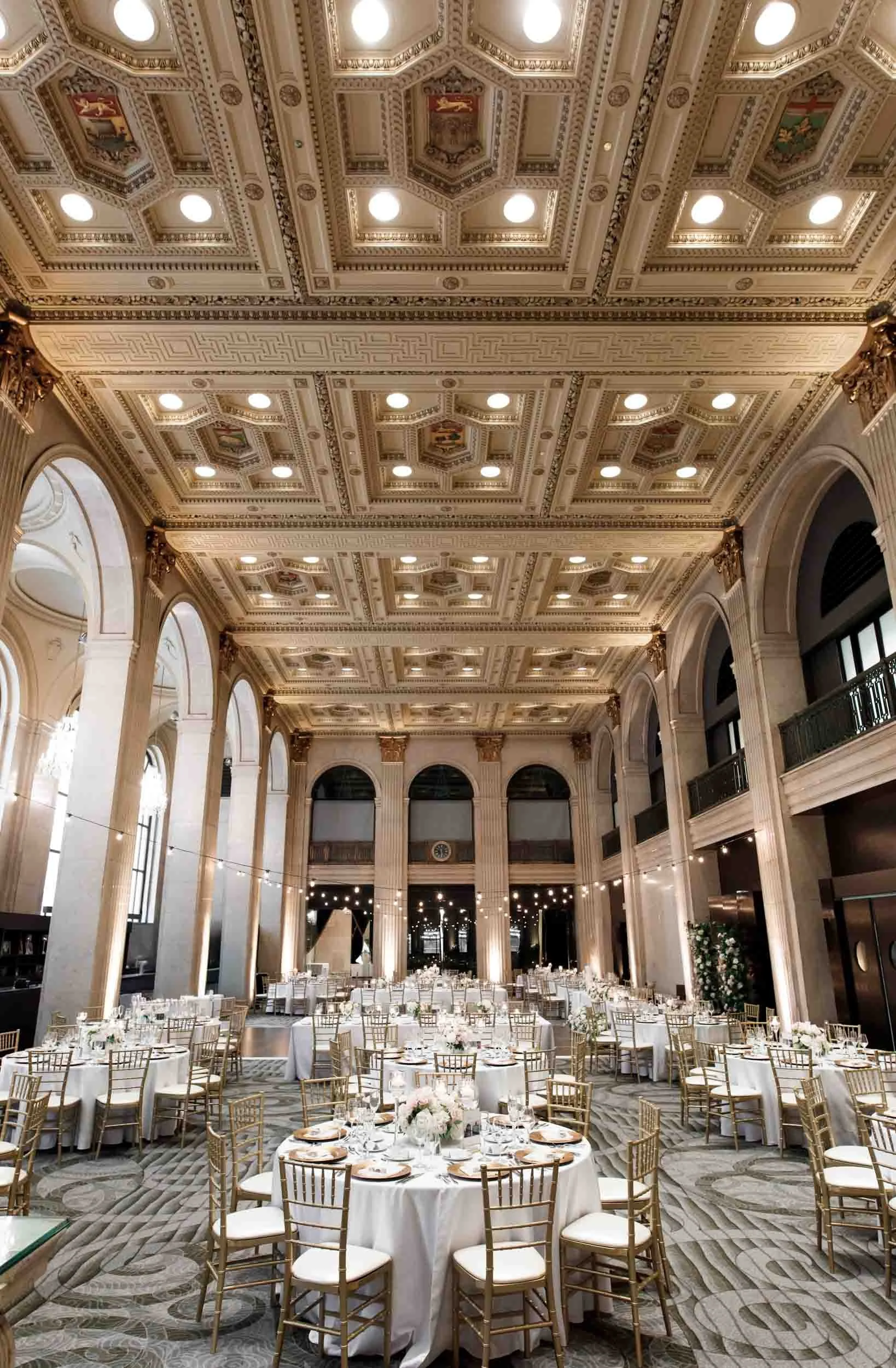 Wide view of a formal wedding reception space at One King West with round tables and chandeliers (Copy)