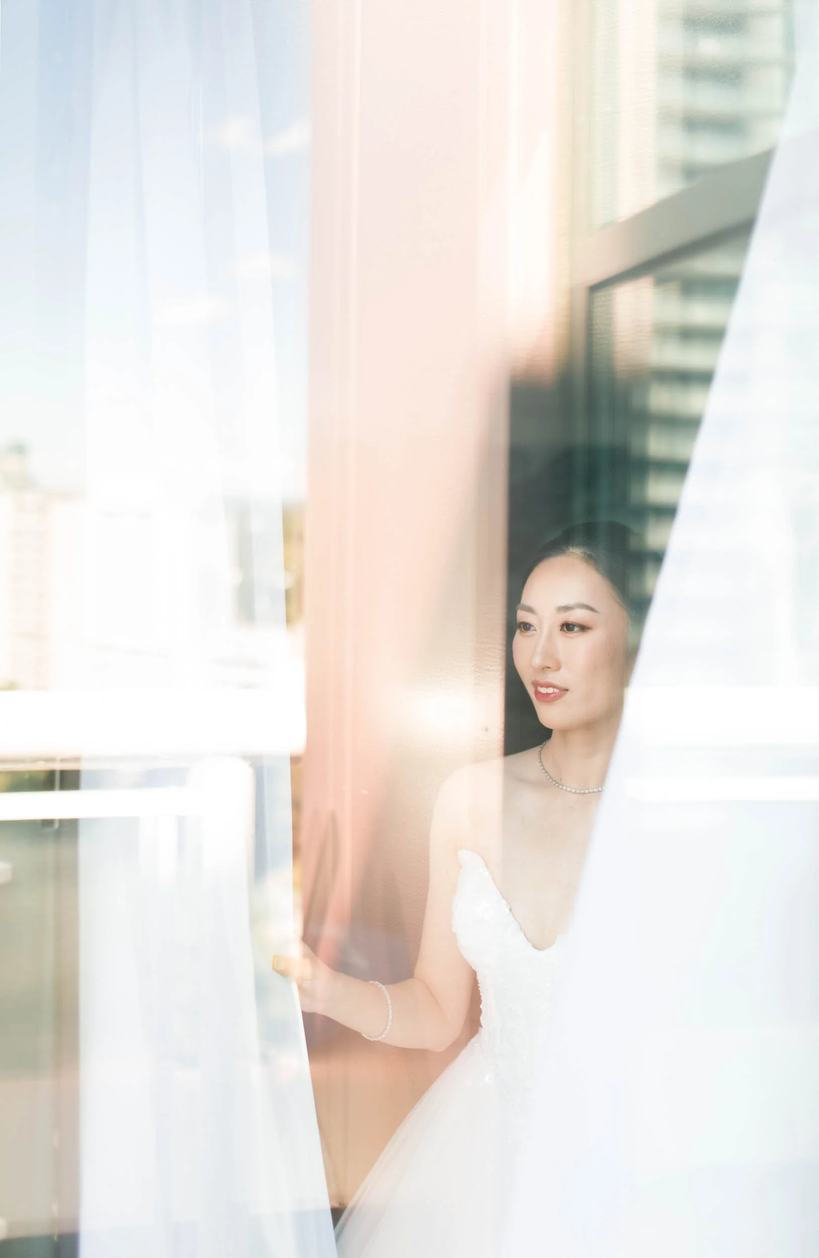 Bride looking out the window during wedding preparations at Novotel in Toronto (Copy)