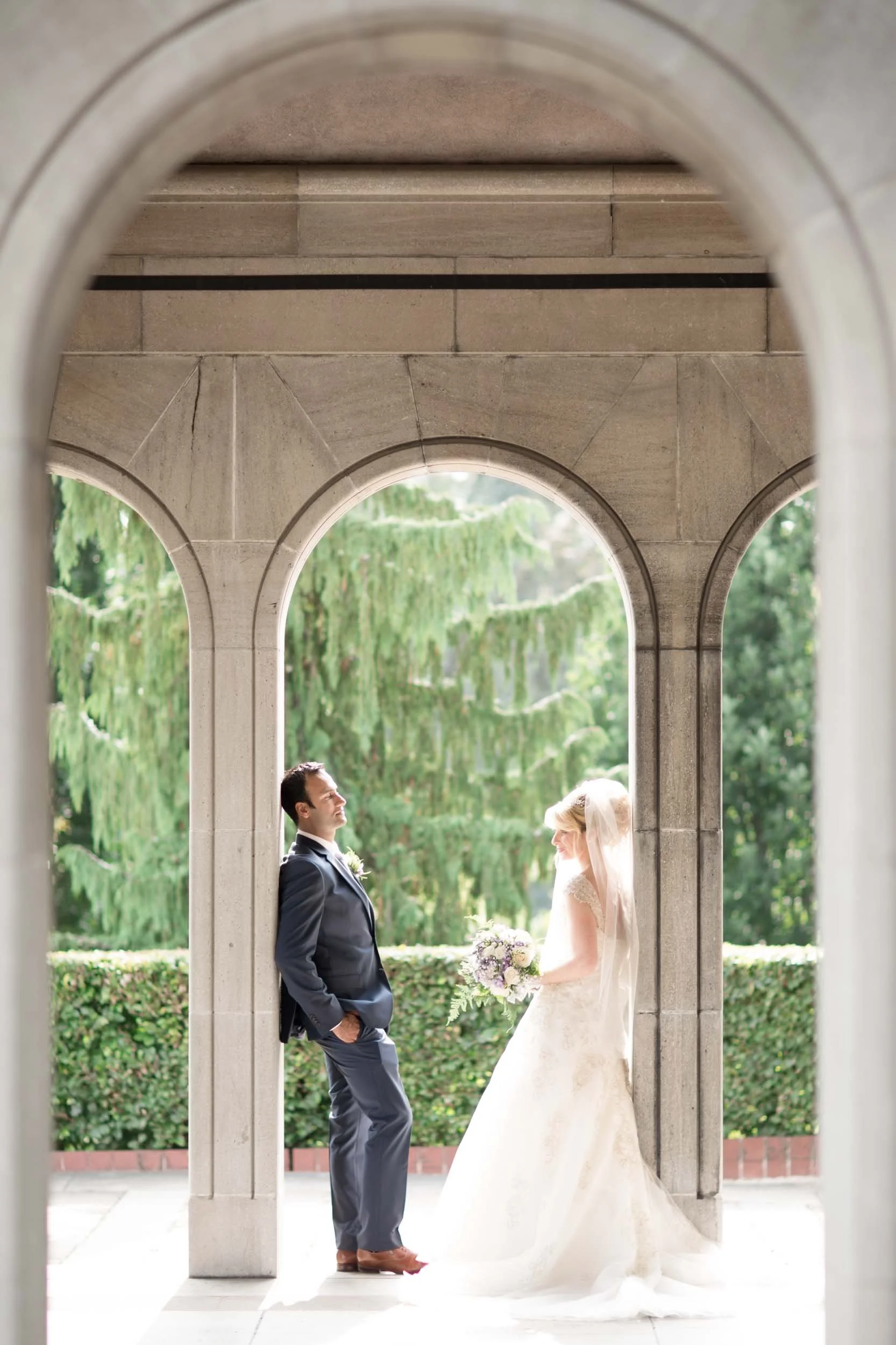 Bride and groom facing each other under stone arches at Oakes Garden Theatre in Niagara Falls (Copy)