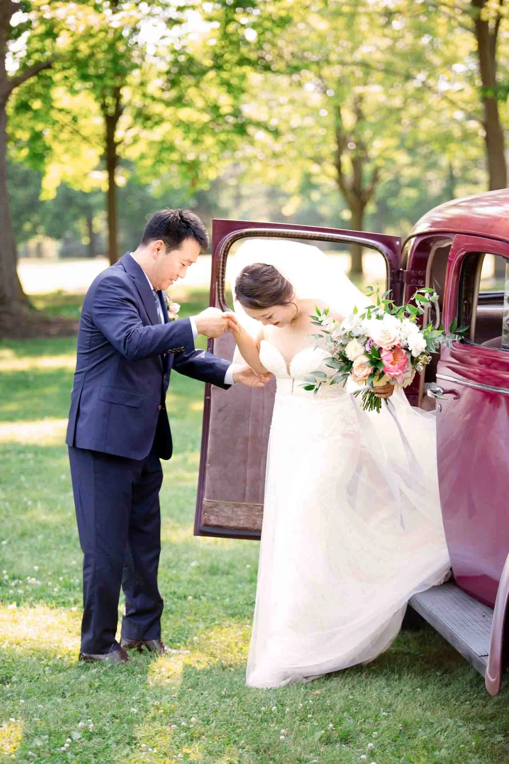 Father of the bride guiding her out of a vintage car for the ceremony processional at a Niagara Region wedding (Copy)
