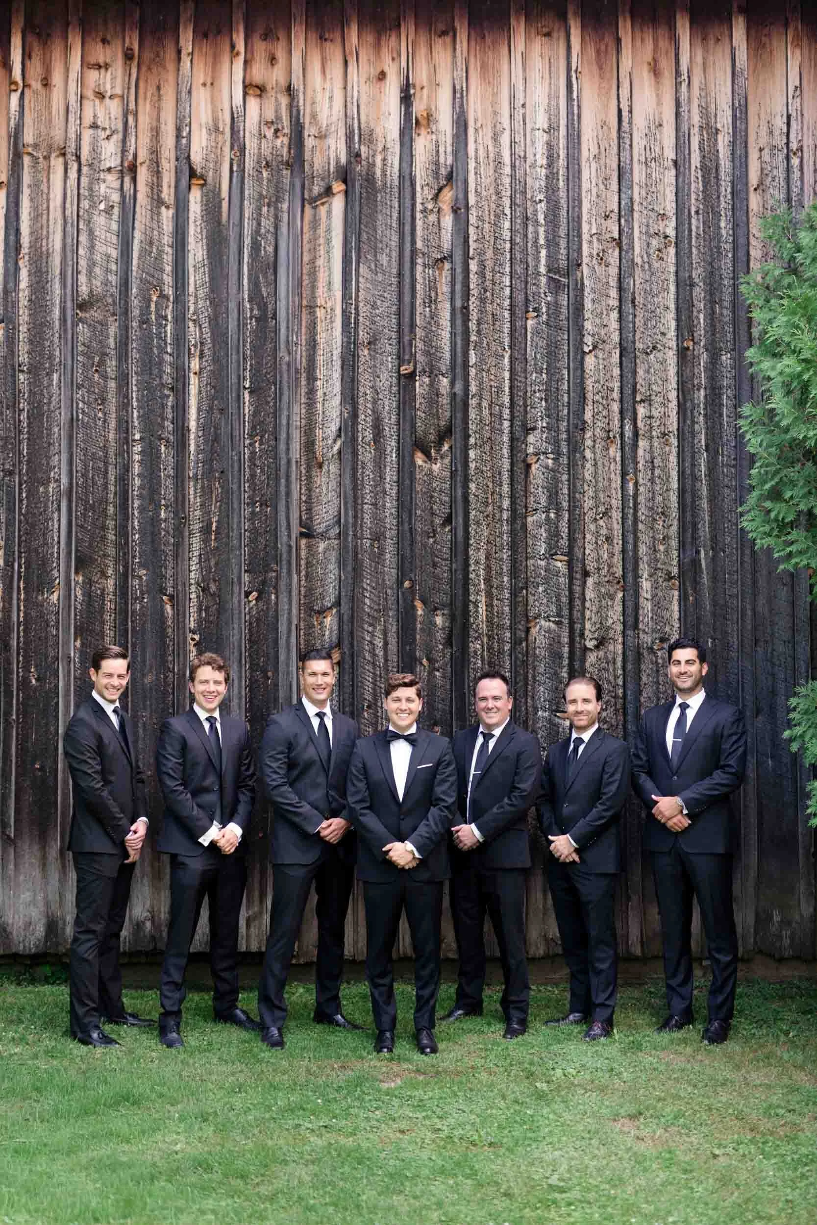 Groomsmen standing together beside a rustic barn at a Balls Falls wedding in Lincoln, Ontario (Copy)