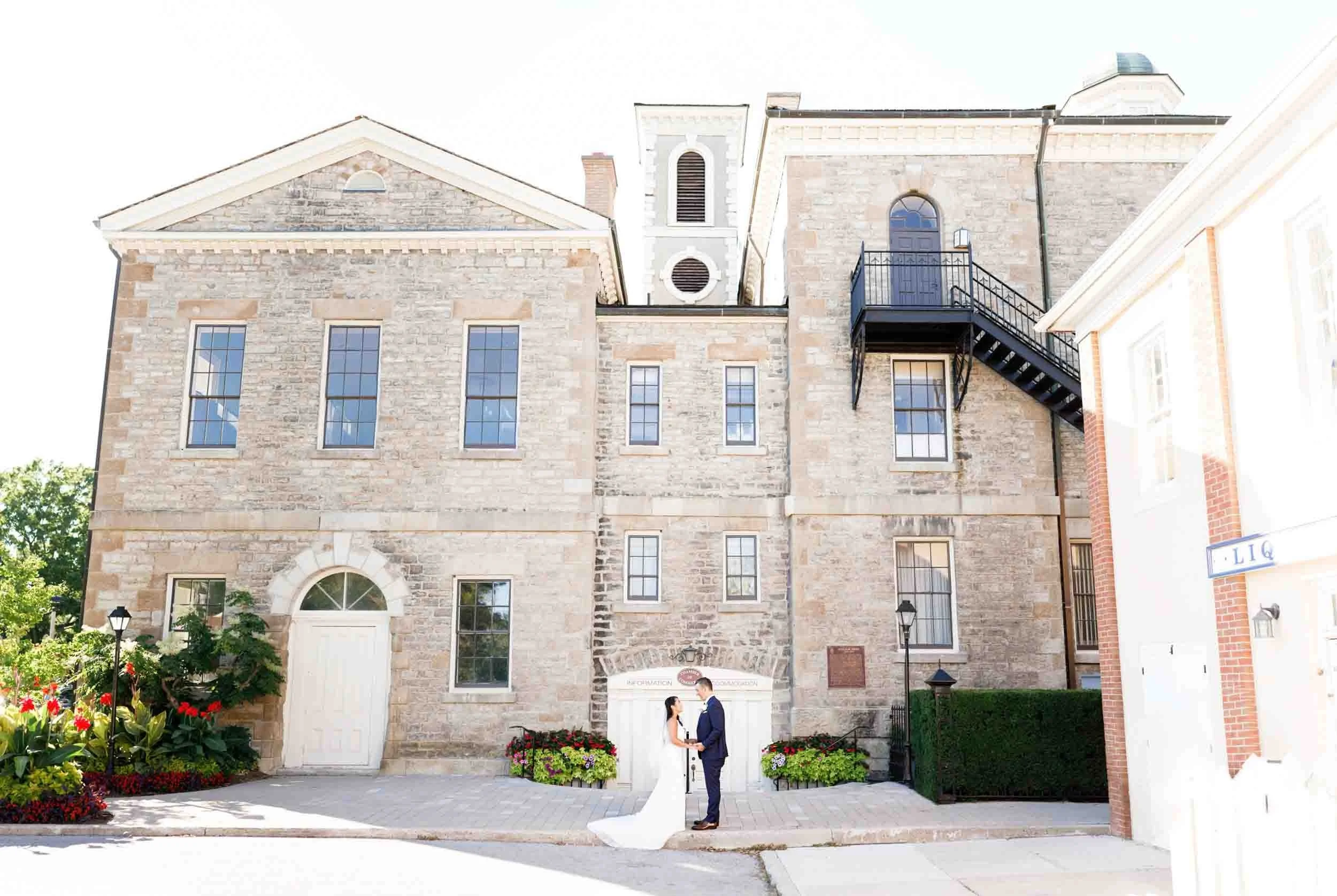 Wide Bride and groom portrait outside the Old Court House in Niagara-on-the-Lake (Copy)