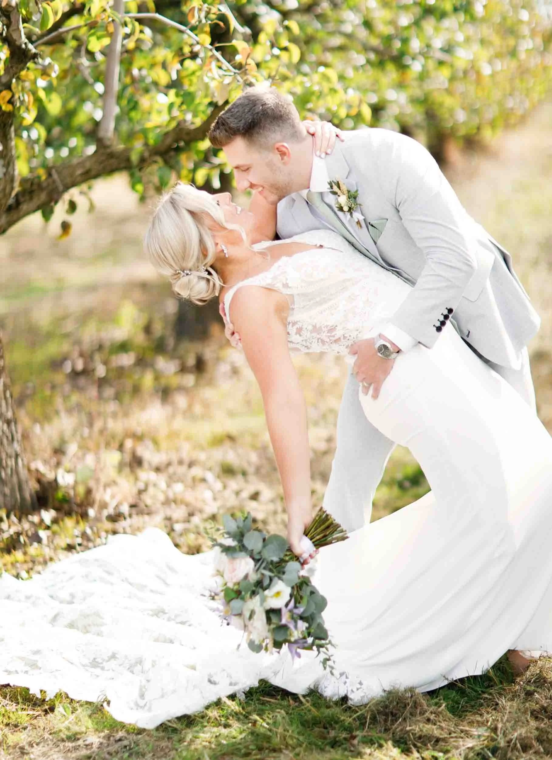 Romantic dip kiss between bride and groom at Sorella Farms orchard in St. Catharines (Copy)