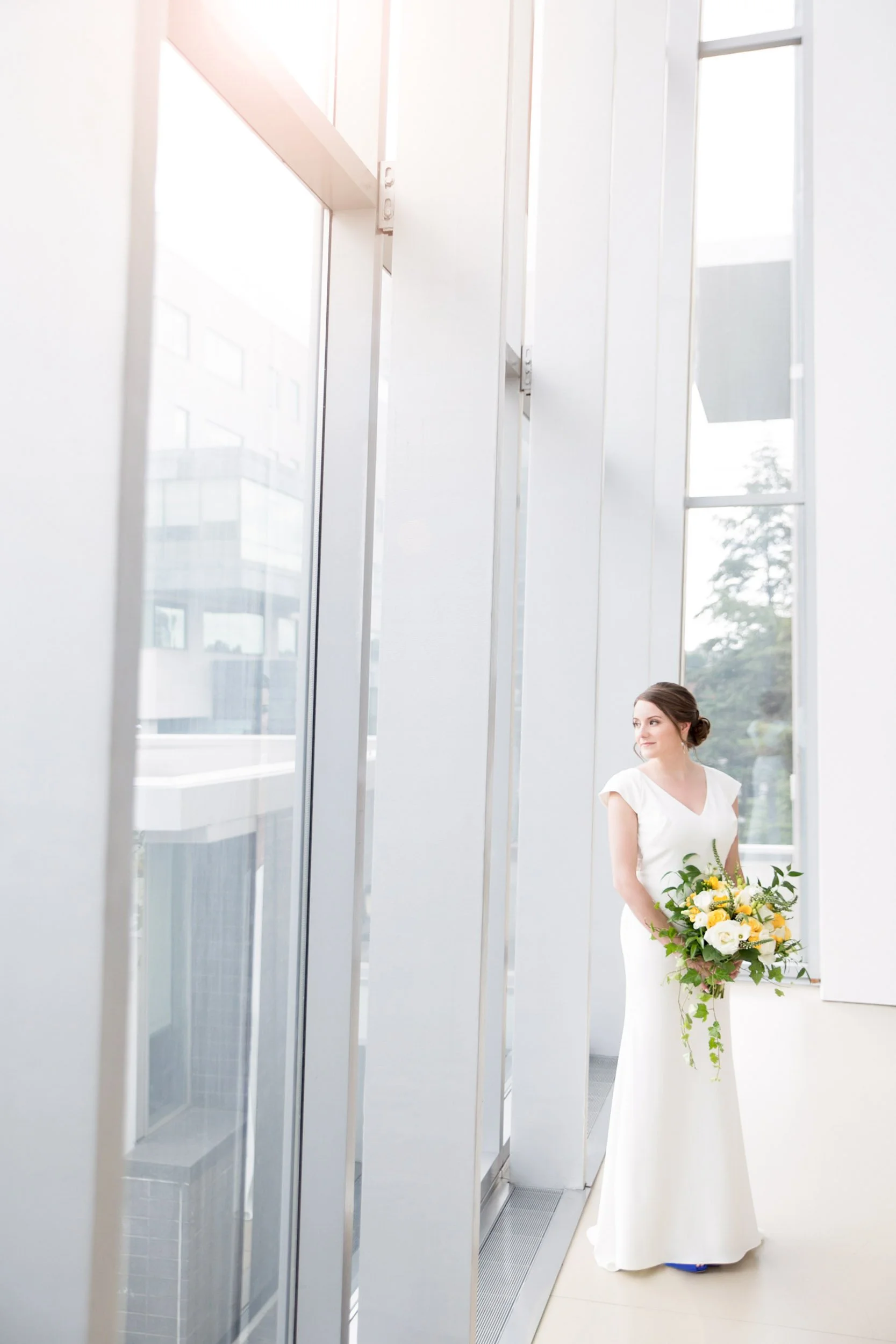 Bride standing by floor-to-ceiling windows at Art Gallery of Hamilton wedding (Copy)