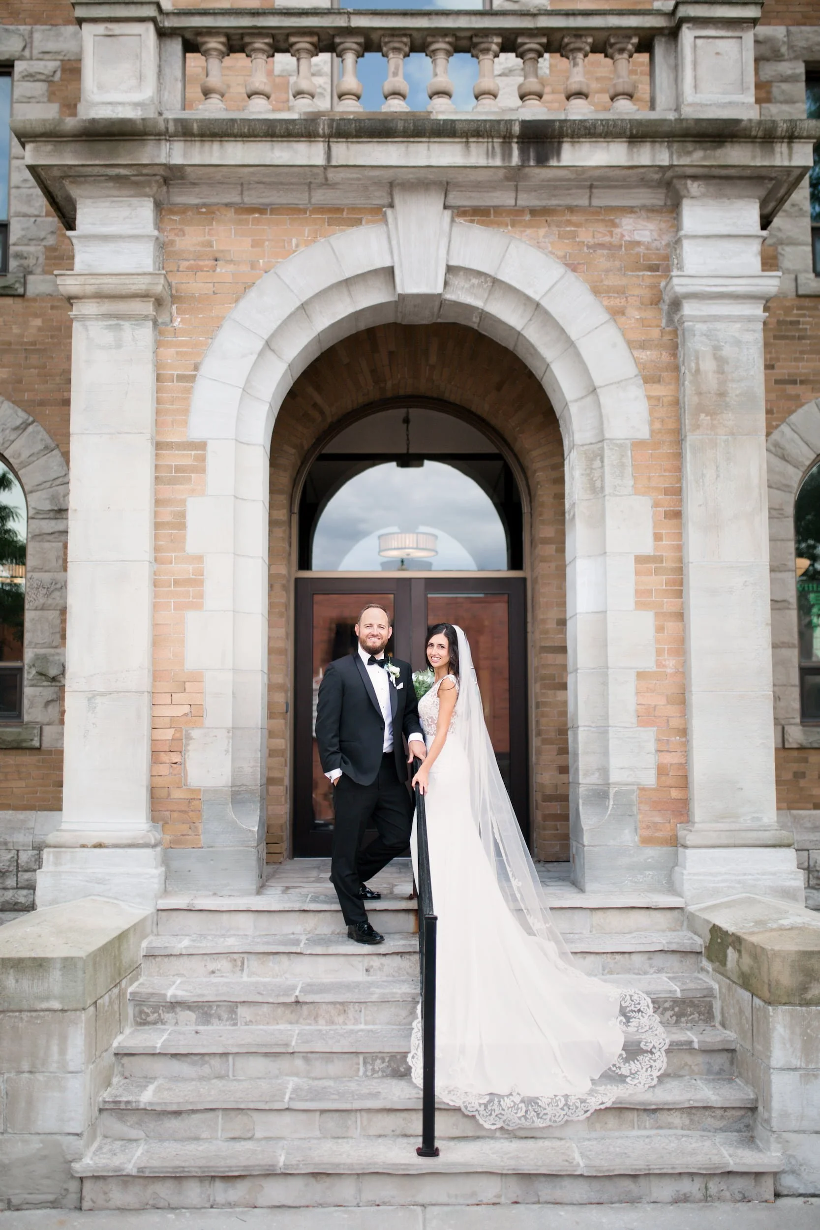Groom portrait beside red brick building in downtown Hamilton (Copy)