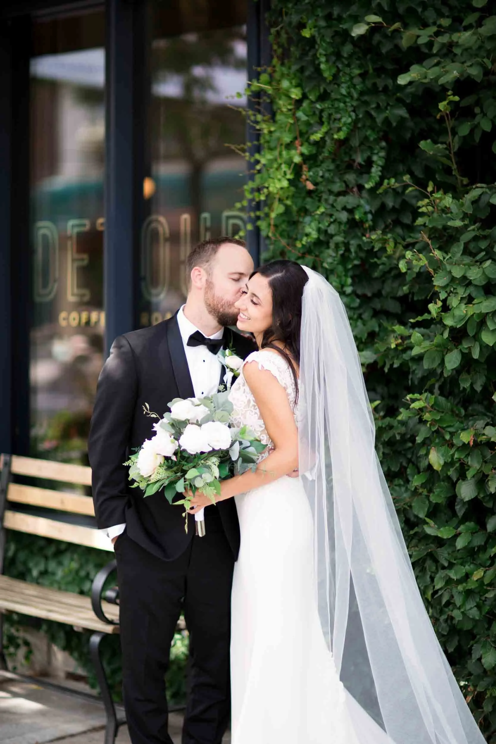 Bride and groom portrait outside ivy-covered storefront in downtown Hamilton (Copy)