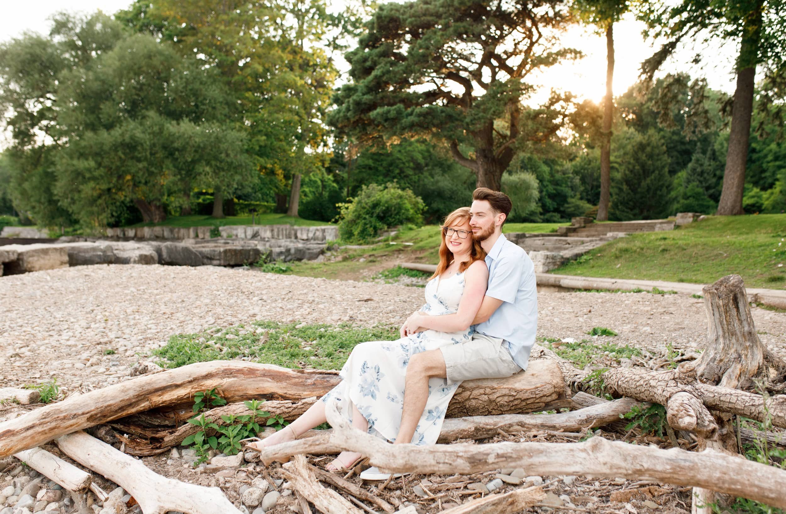 Couple seated on driftwood on the beach during Paletta Mansion engagement in Burlington (Copy)