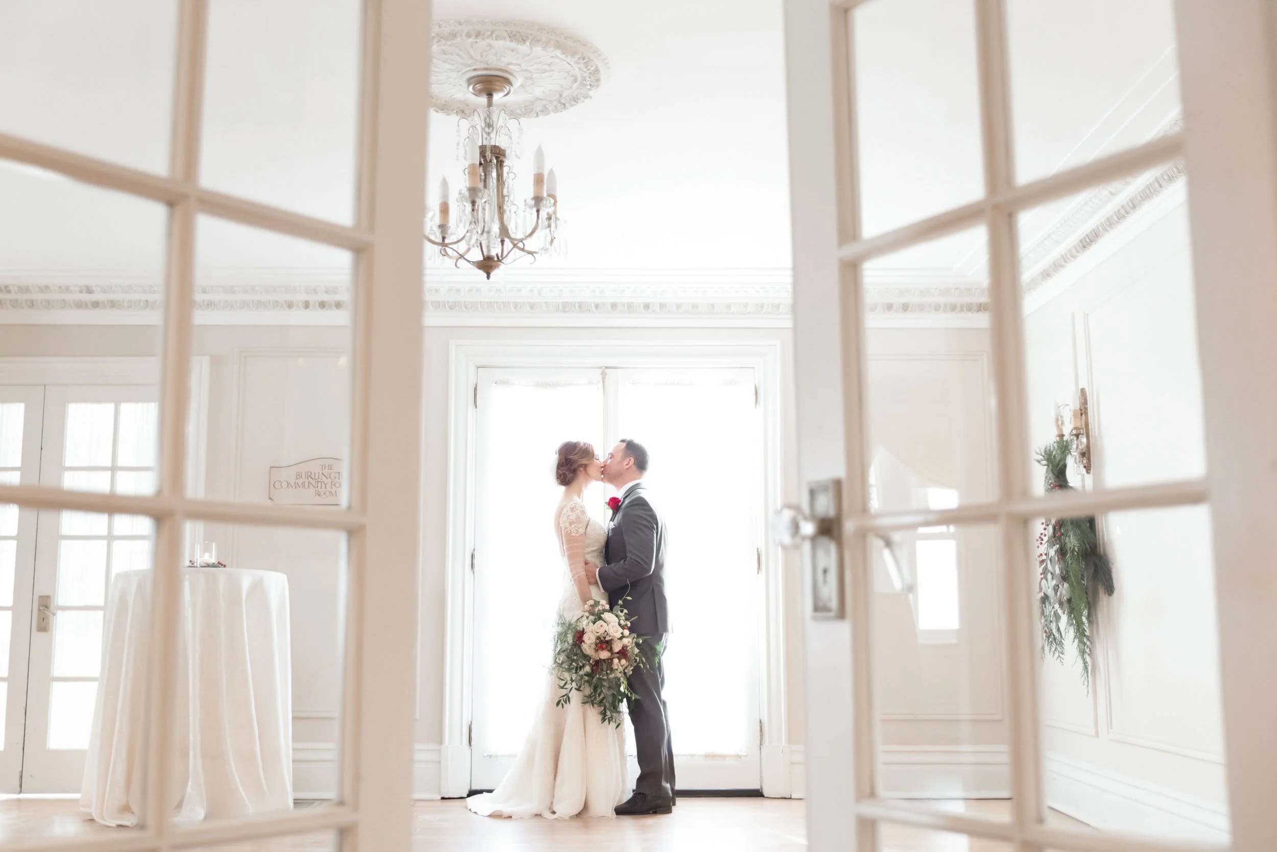 Indoor winter wedding portrait of romantic kiss between bride and groom at Paletta Mansion in Burlington (Copy)