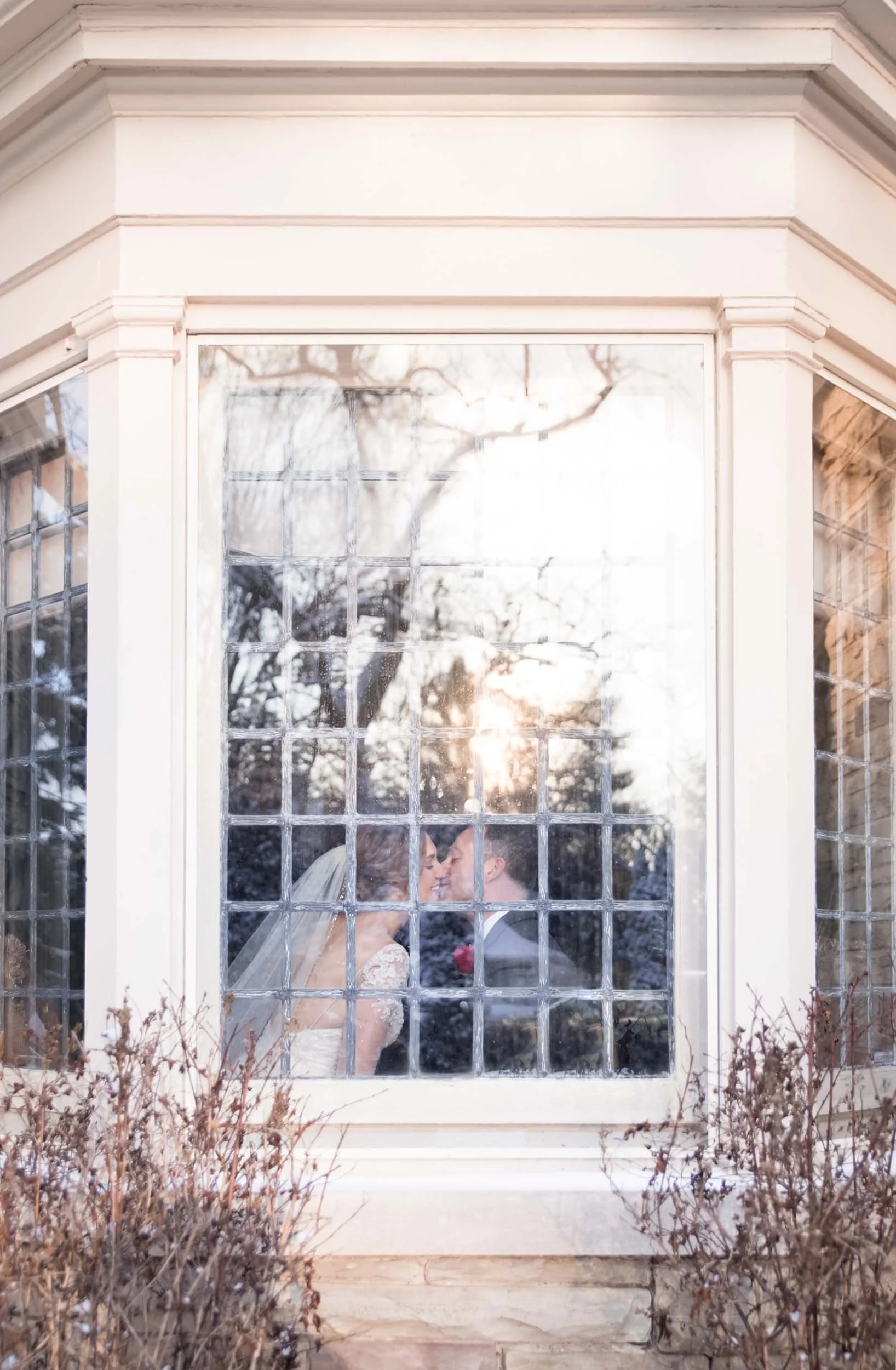 Bride reflected in frosted window at Paletta Mansion winter wedding in Burlington, Ontario (Copy)