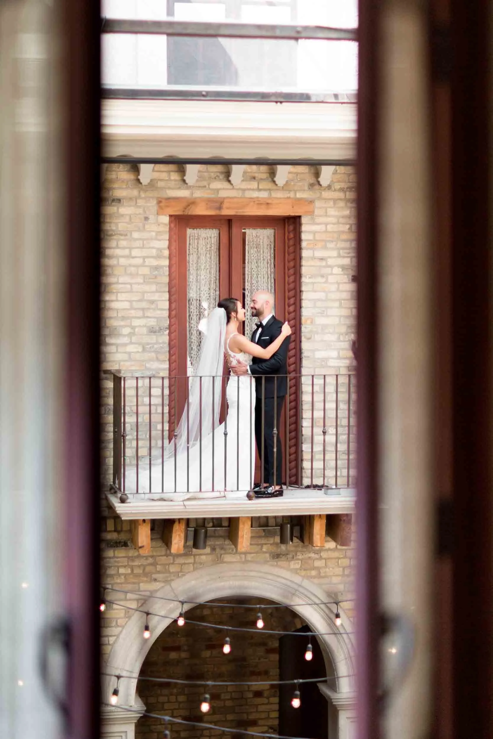 Bride and groom standing together on a balcony during a classic Cambridge wedding at Hacienda Sereda (Copy)