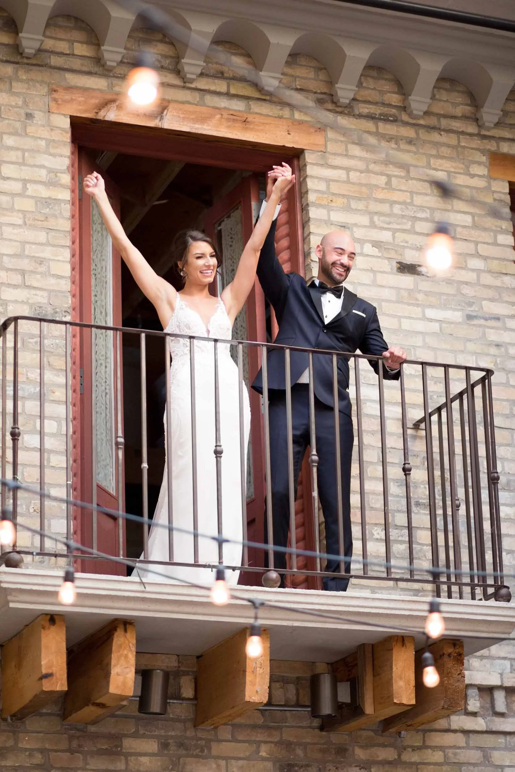 Bride and groom celebrating together on the balcony at Hacienda Sereda during a Cambridge wedding (Copy)