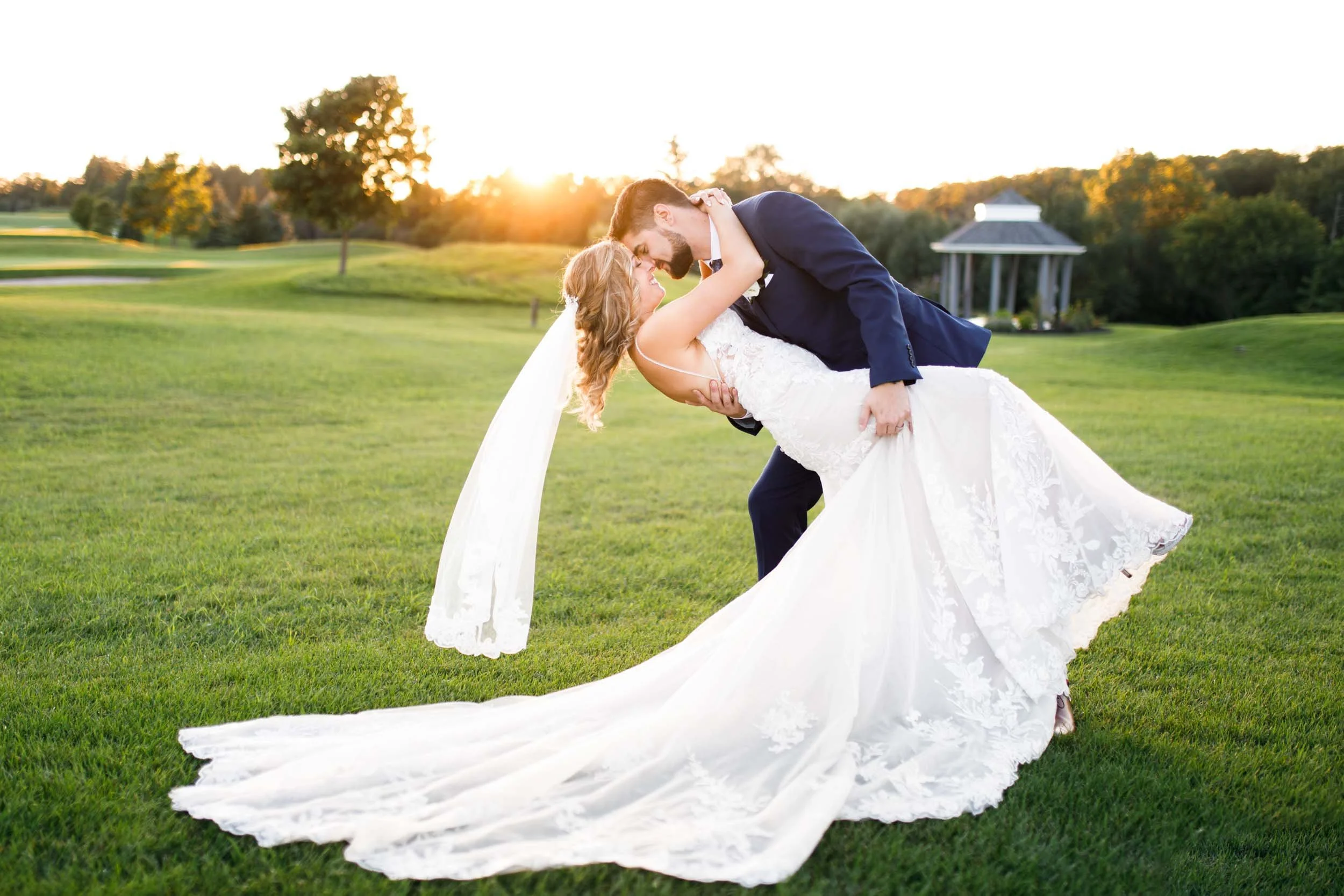 Bride and groom sharing a romantic dip kiss during golden-hour wedding portraits at Whistle Bear in the Waterloo Region (Copy)