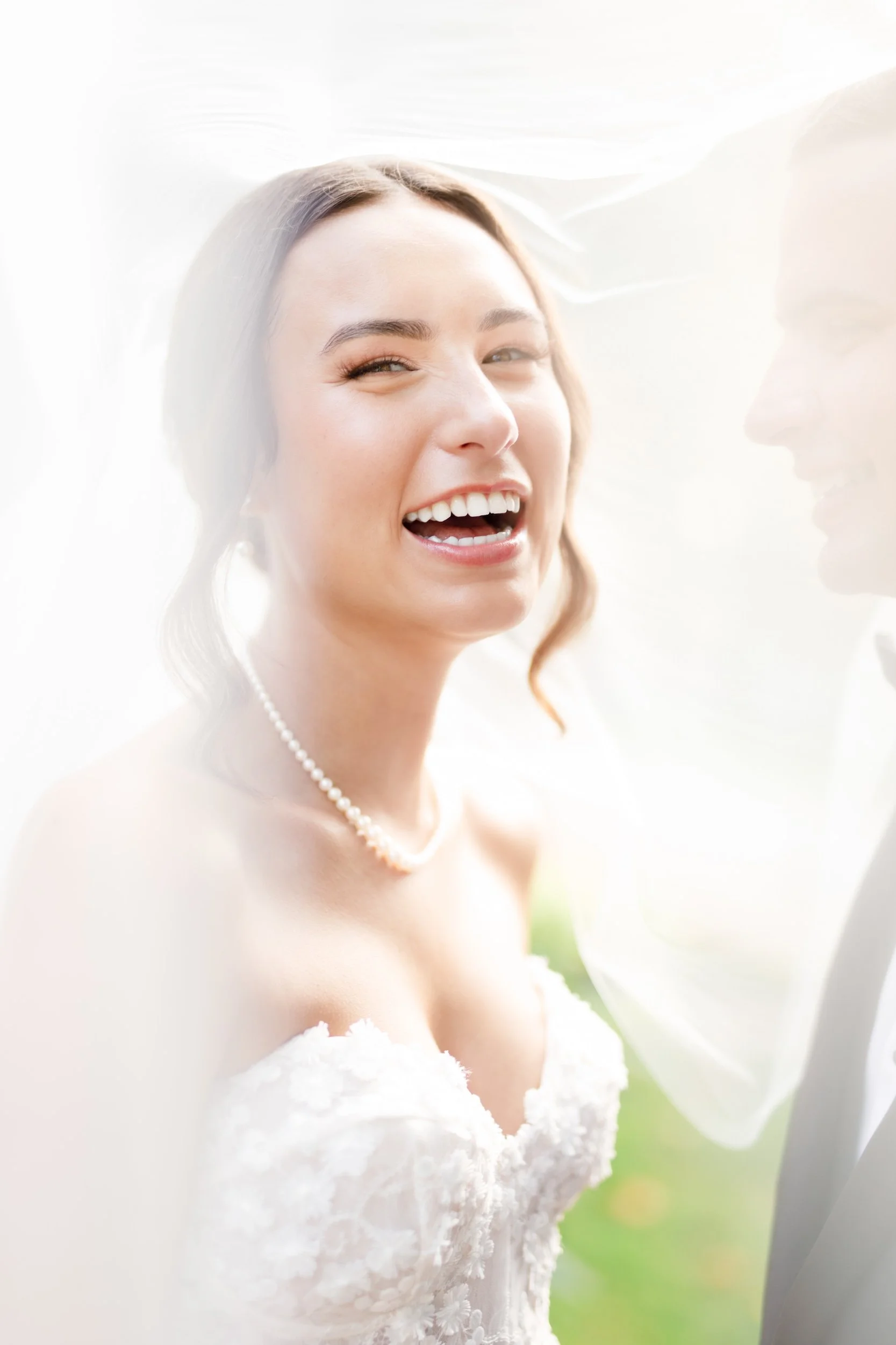 Bride joyfully laughing under her veil during elegant Oakville wedding portrait - View Wedding Portfolio