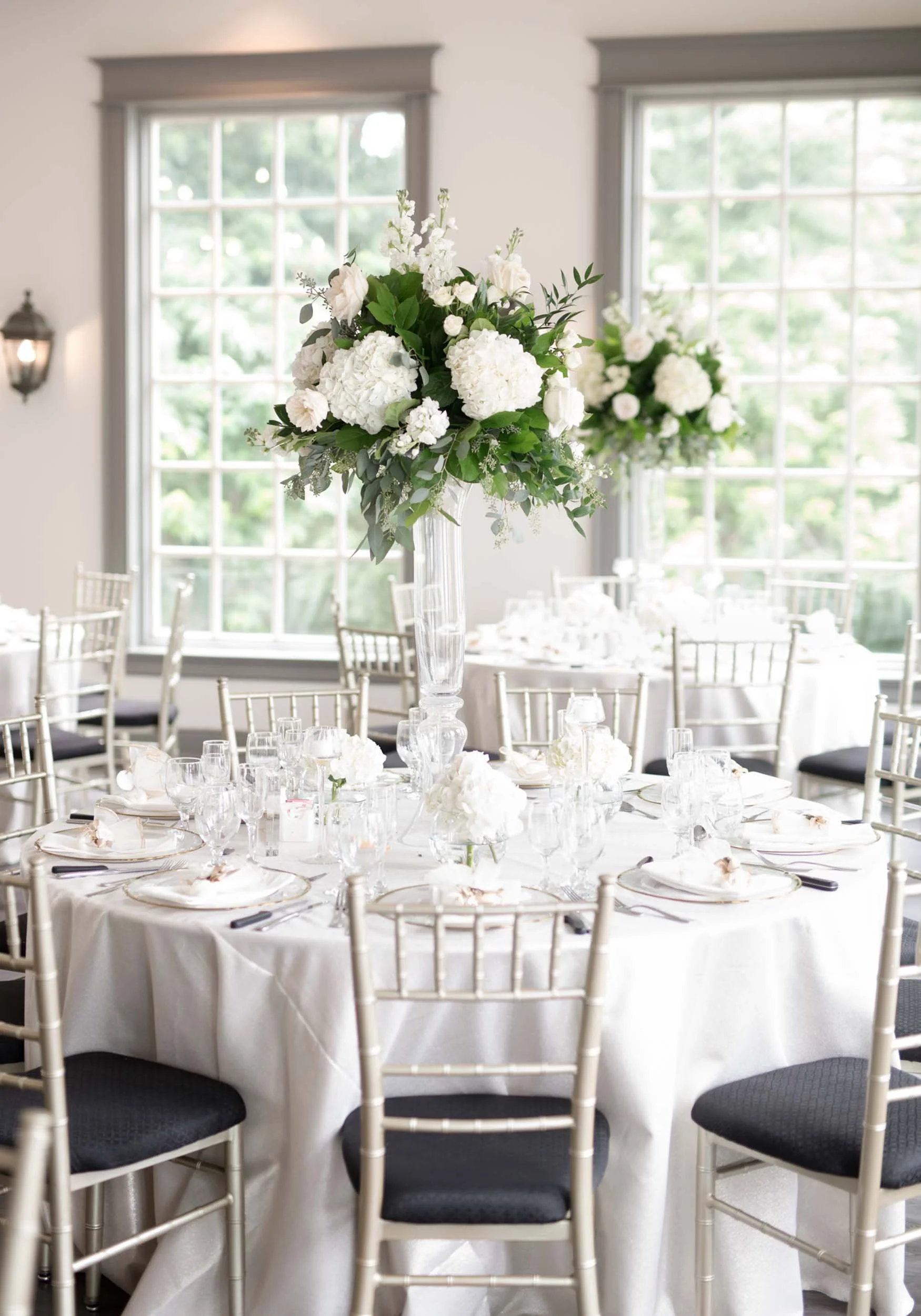 Elegant reception tables beneath large windows at The Doctor’s House in Kleinburg, Ontario