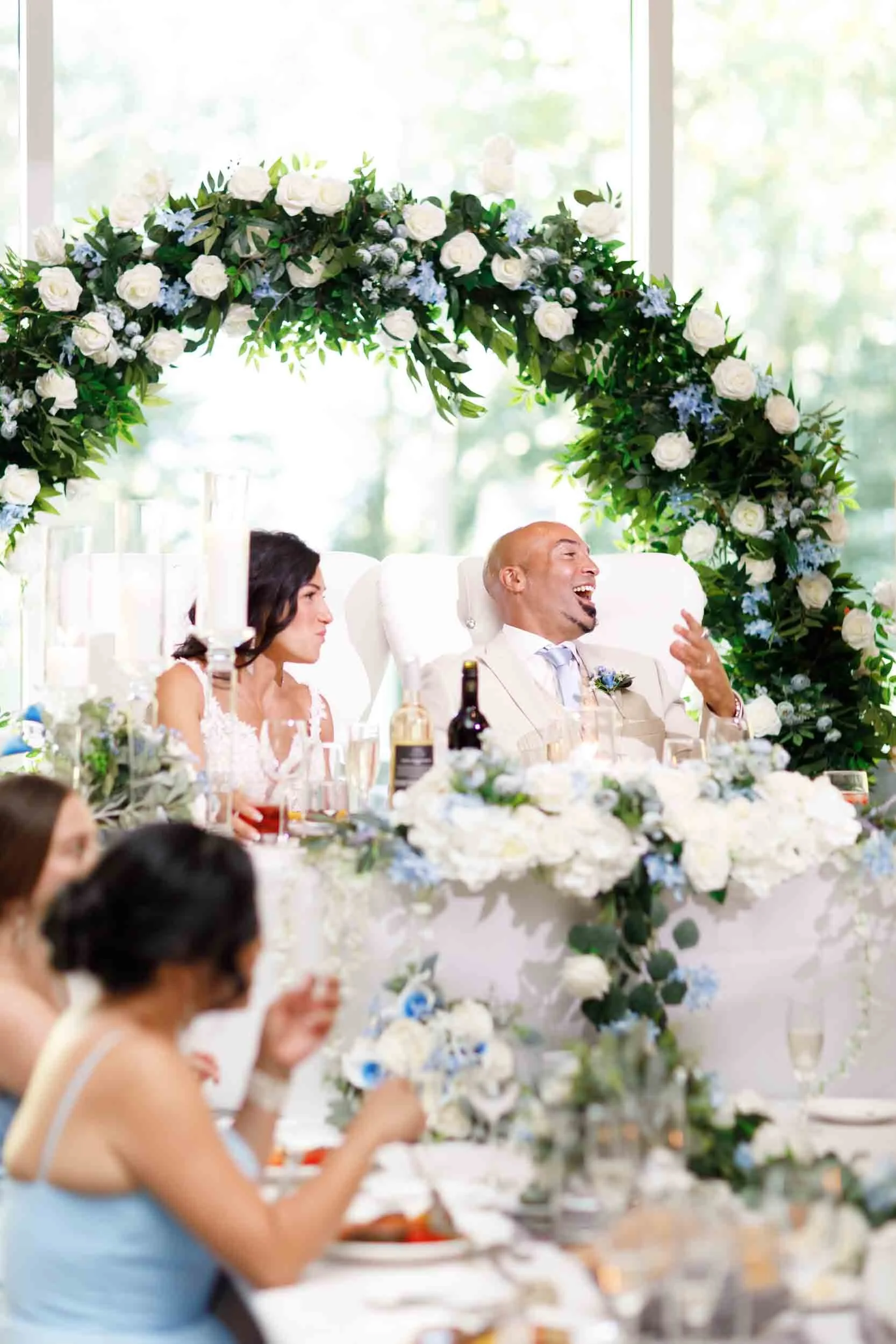 Head table speech beneath floral arch at Guild Inn Estate wedding reception