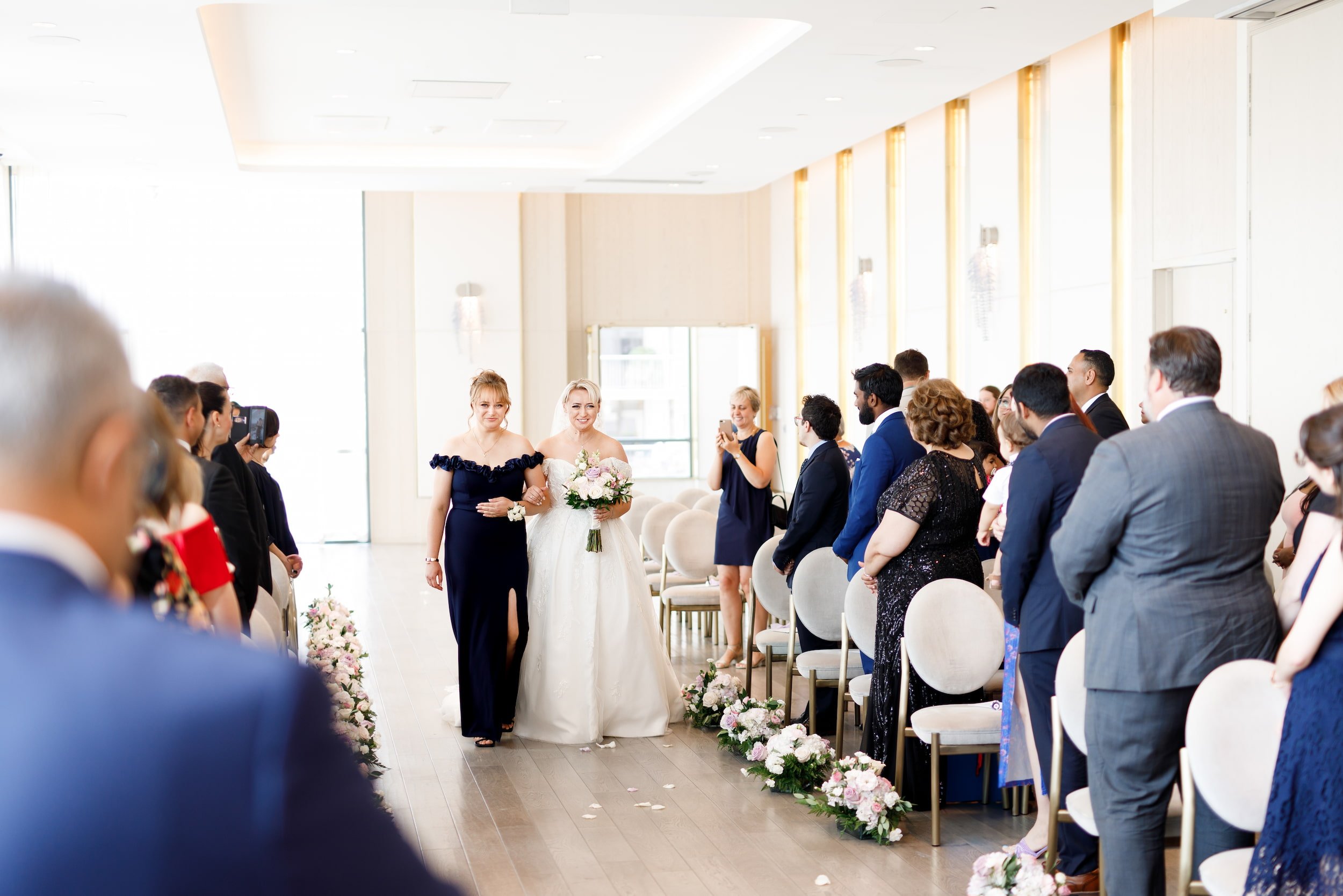 Bride walking down aisle inside modern ballroom at The Pearle Hotel & Spa in Burlington
