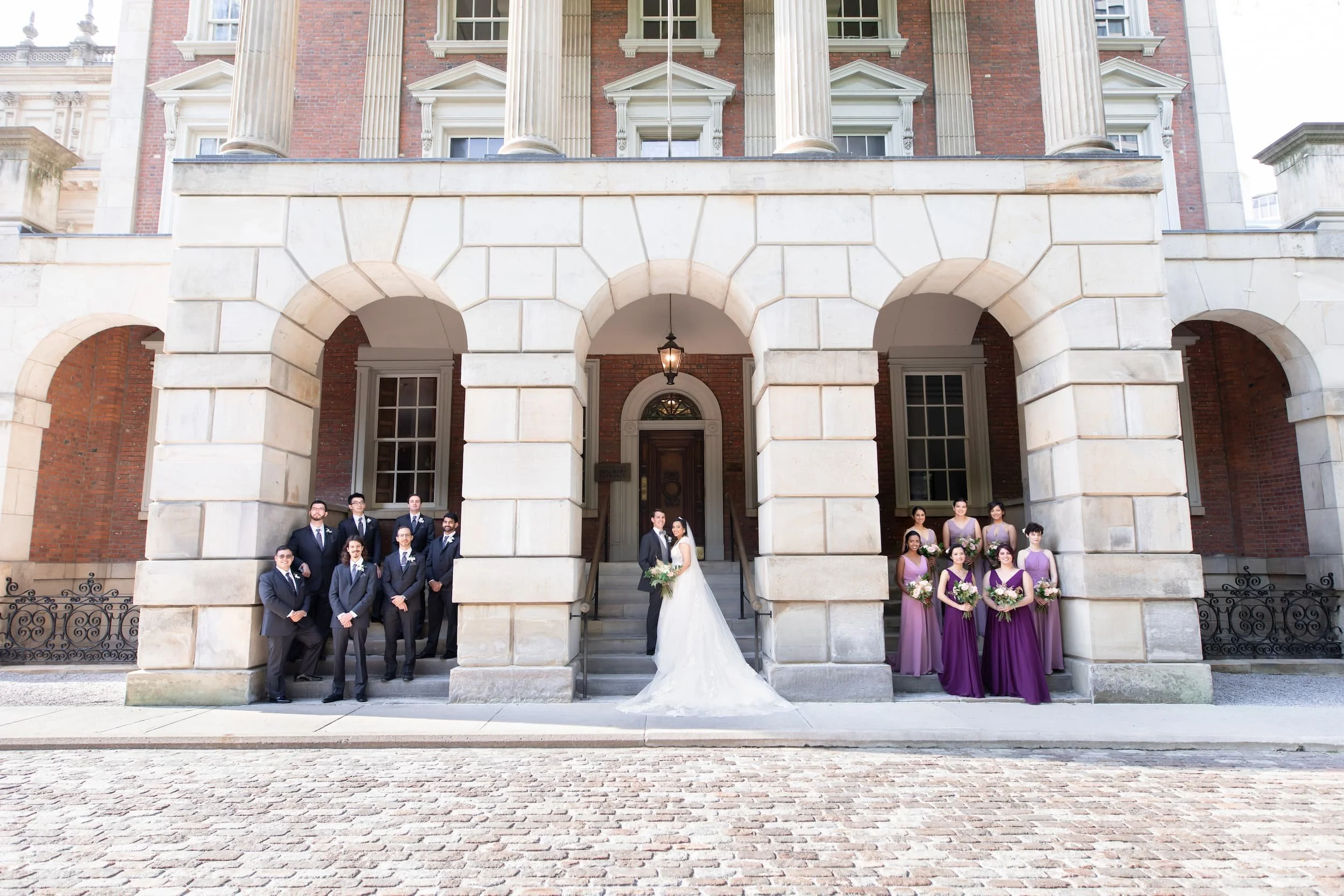 Wedding portrait framed by arched entrance at Osgoode Hall in downtown Toronto