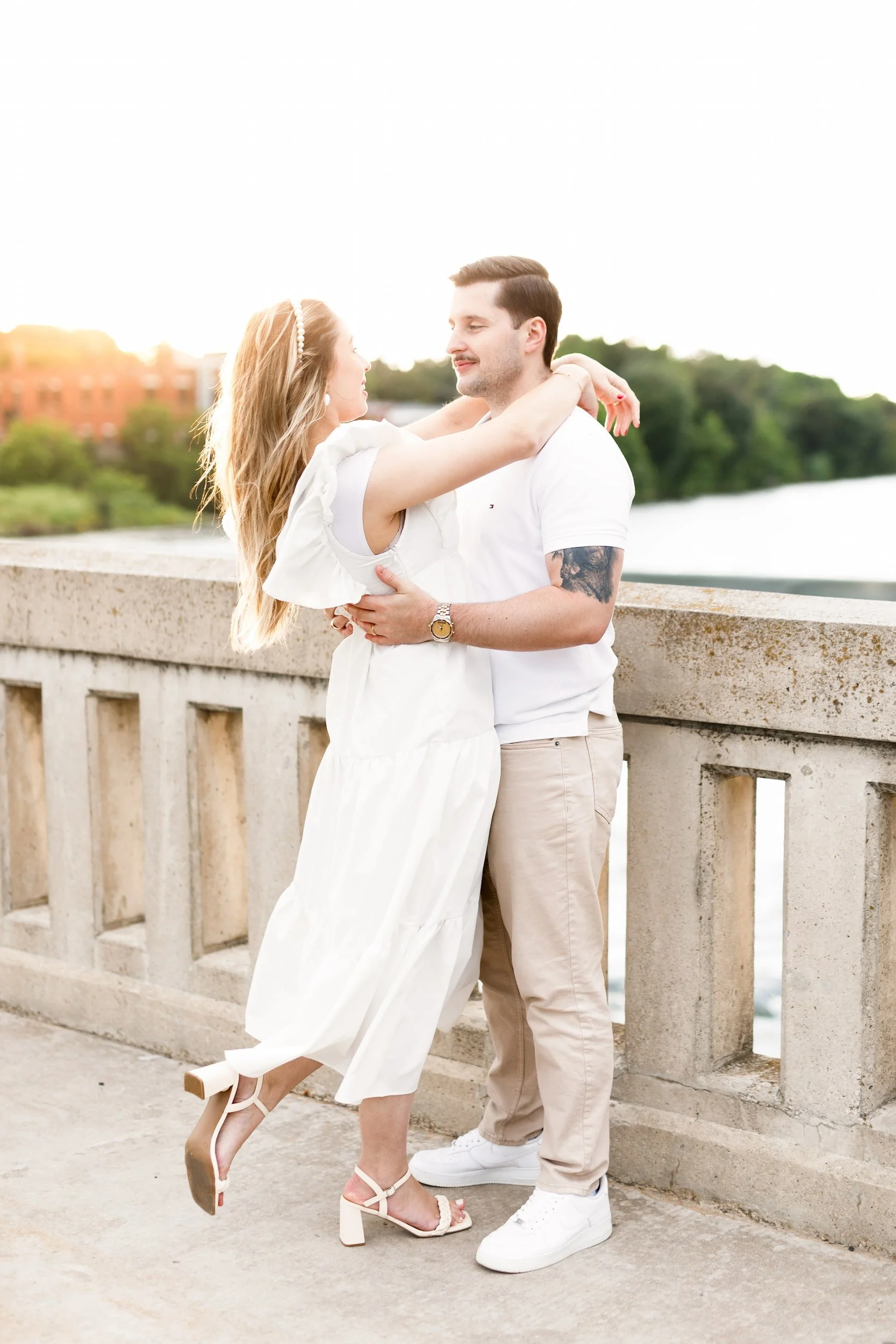 Couple embracing along Grand River railing near Cambridge Mill in Cambridge