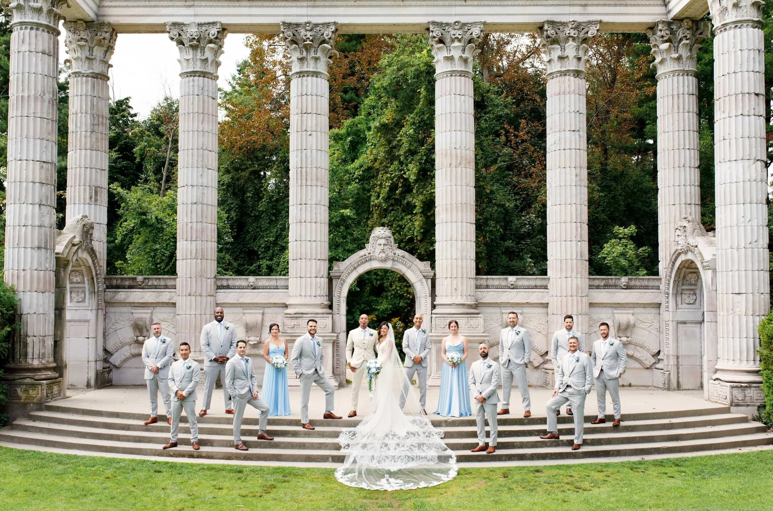 Wide epic wedding party staggered portrait at Guild Inn Estate Greek Theatre columns