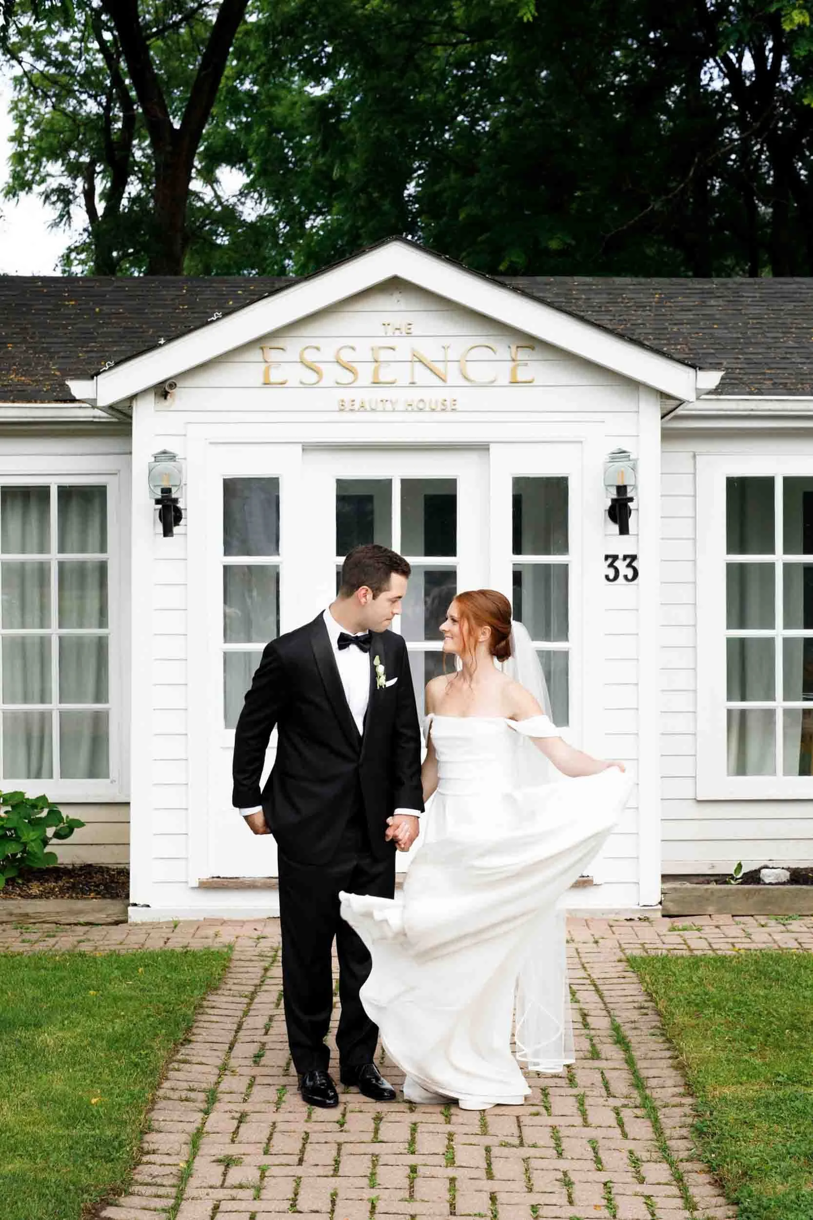 Bride and groom walking in front of The Essence venue at The Doctor’s House in Kleinburg, Ontario