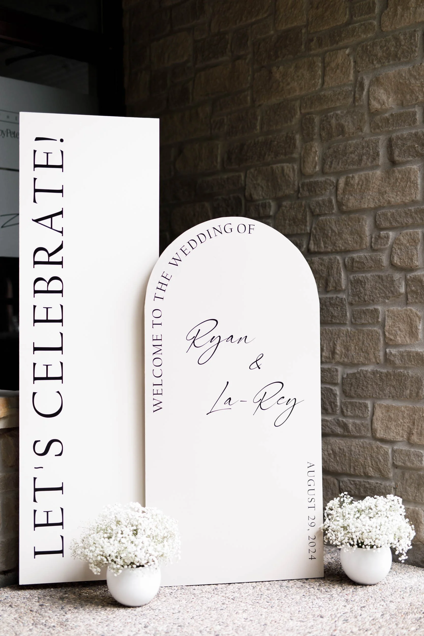 Minimalist wedding welcome sign against stone wall at The Manor Event Venue in King, Ontario