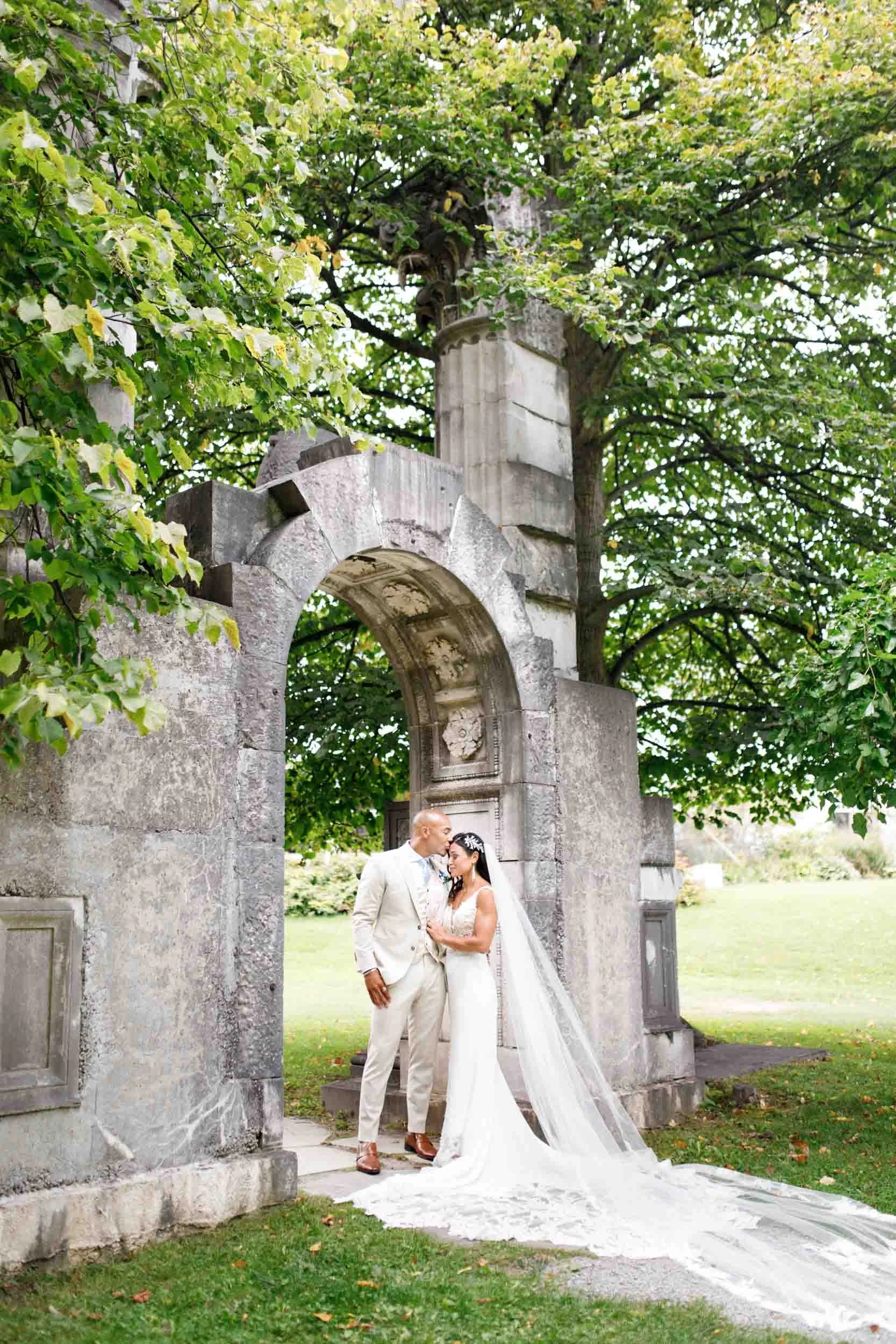 Romantic portrait framed by Guild Inn Estate garden archway