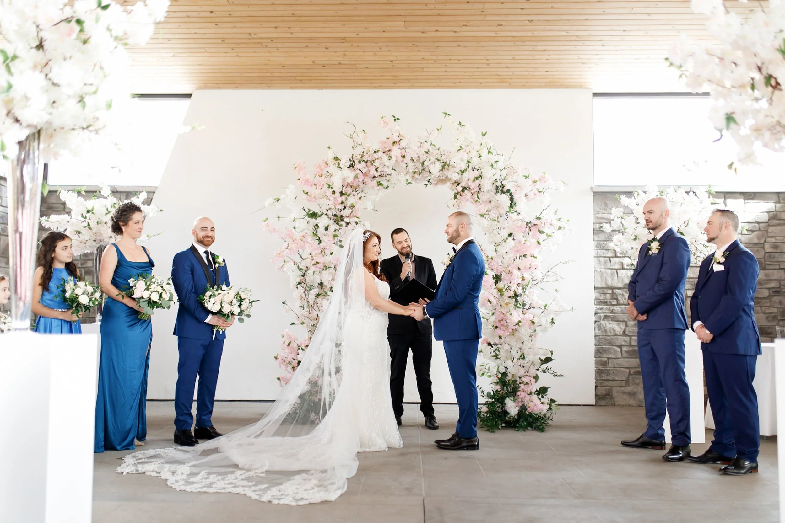 Outdoor ceremony beneath floral arch at Guild Inn Estate