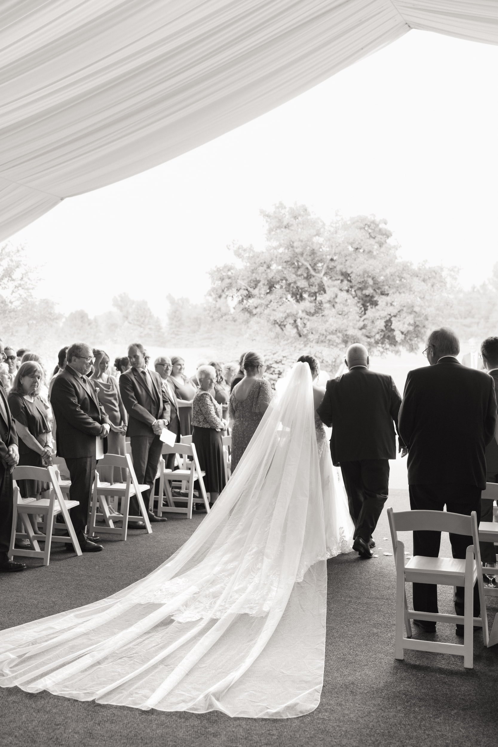 Black and white aisle entrance moment during outdoor ceremony at The Manor Event Venue wedding in King, Ontario