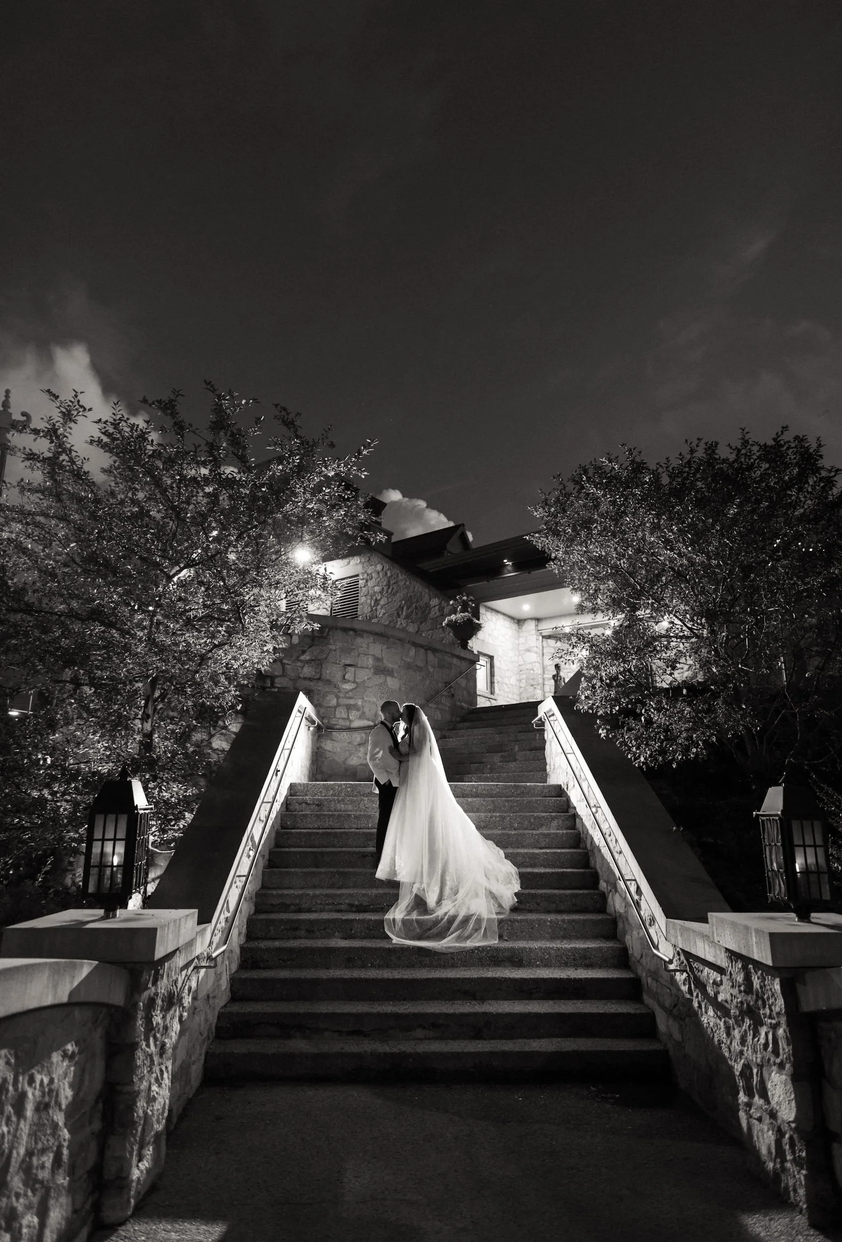 Black and white night wedding portrait on grand stone staircase leading up to the Cambridge Mill in Cambridge, Ontario