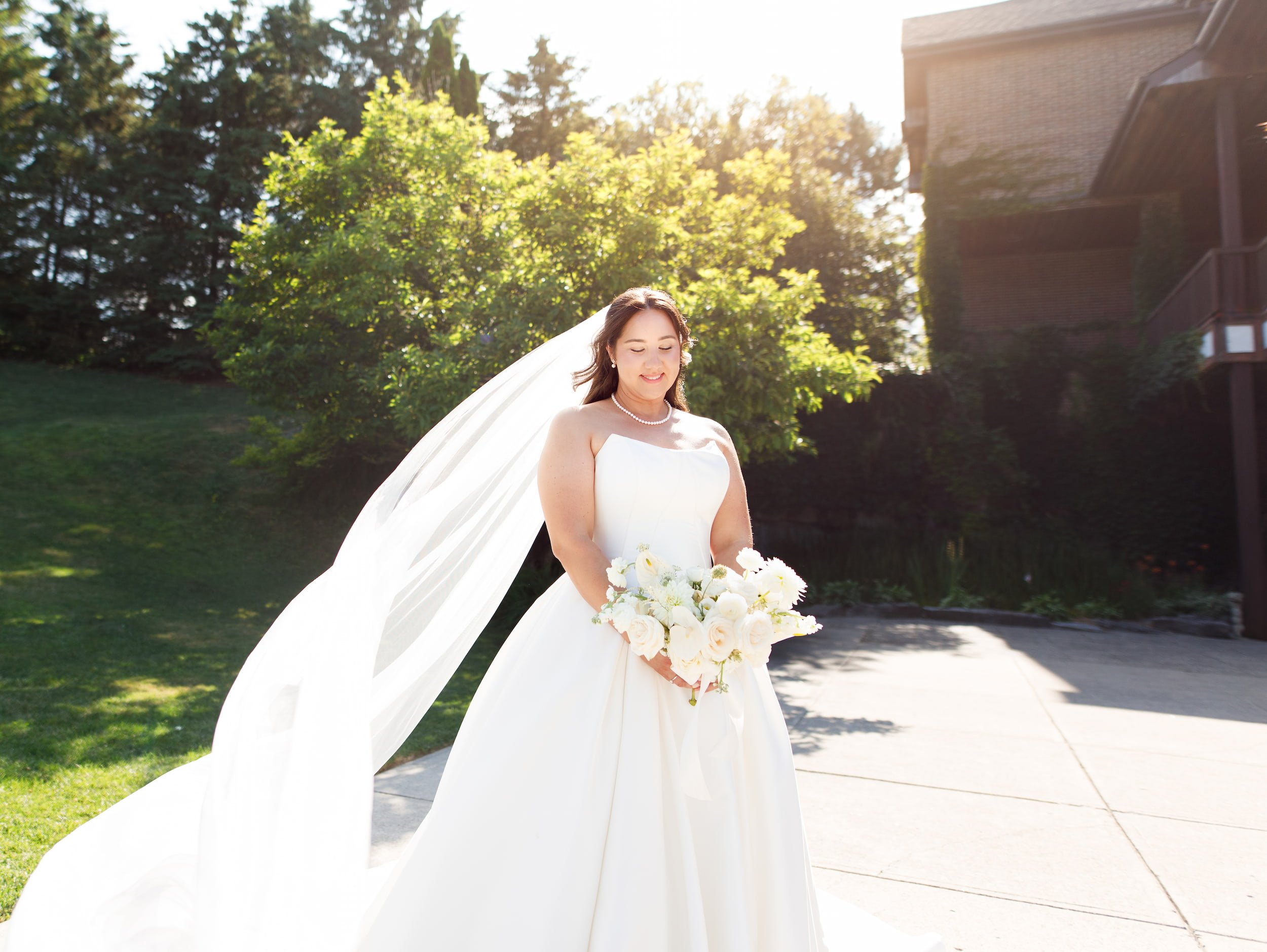 Bride holding bouquet in golden sunlight at The Manor Event Venue wedding in King, Ontario