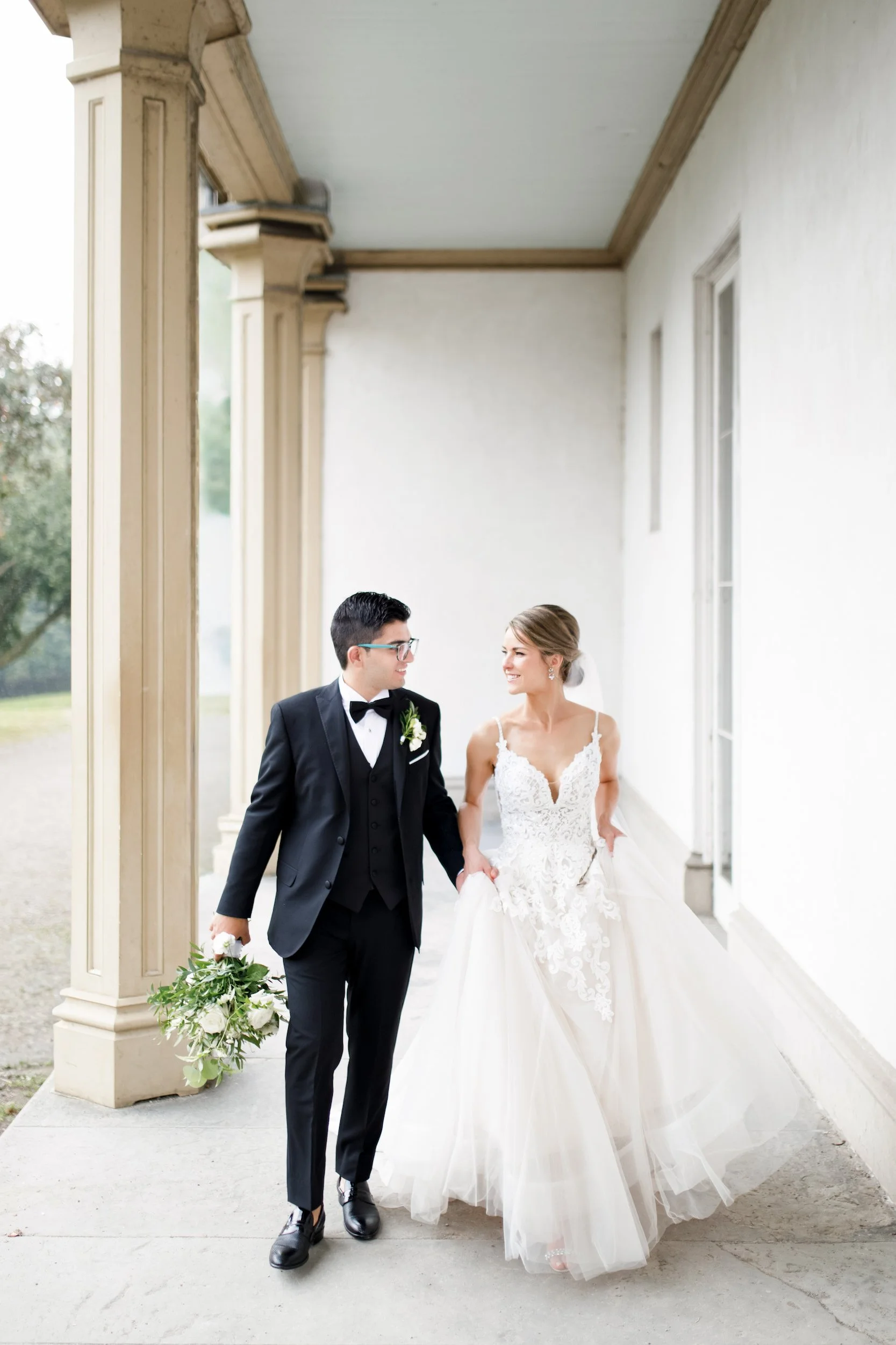 Bride and groom walking along Dundurn Castle columns