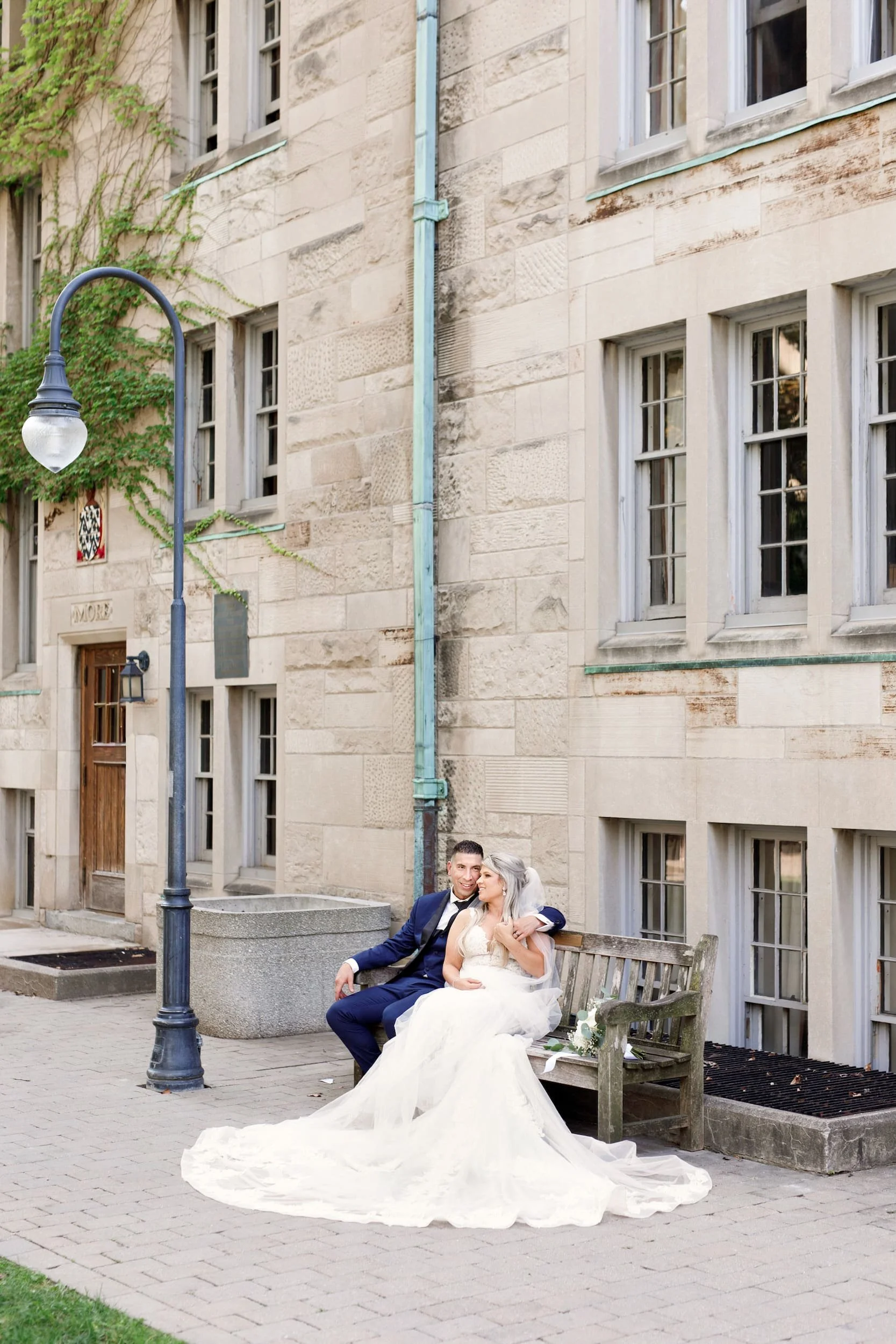 Bride and groom relaxing in campus courtyard at St. Michael’s College, University of Toronto in Toronto, Ontario