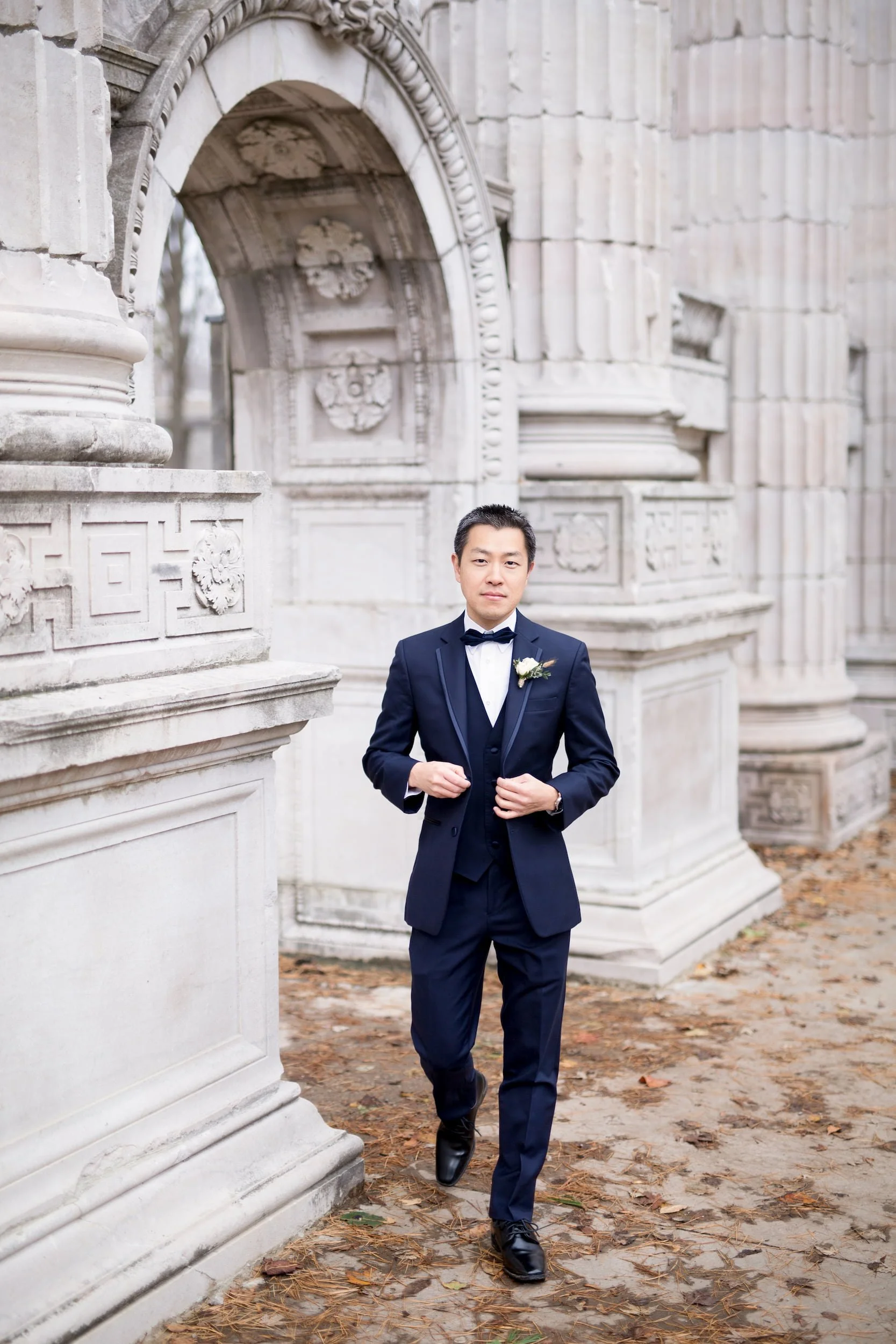 Groom portrait among historic stone columns at Guild Inn Estate
