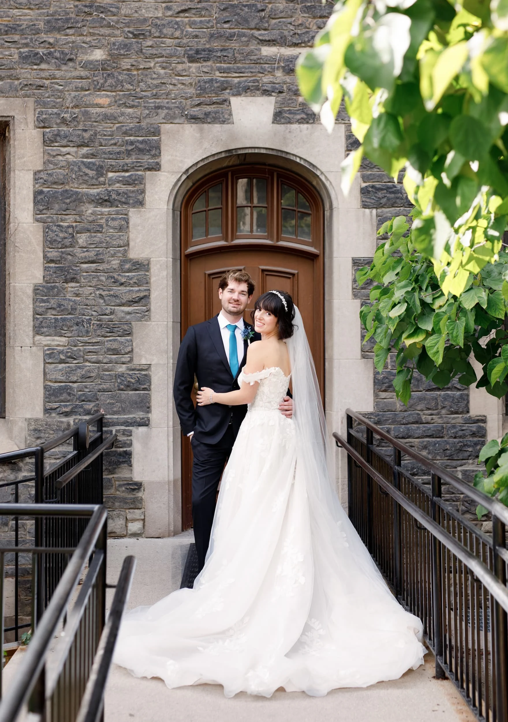 Bride and groom portrait on stone staircase at Victoria College, University of Toronto in Toronto, Ontario