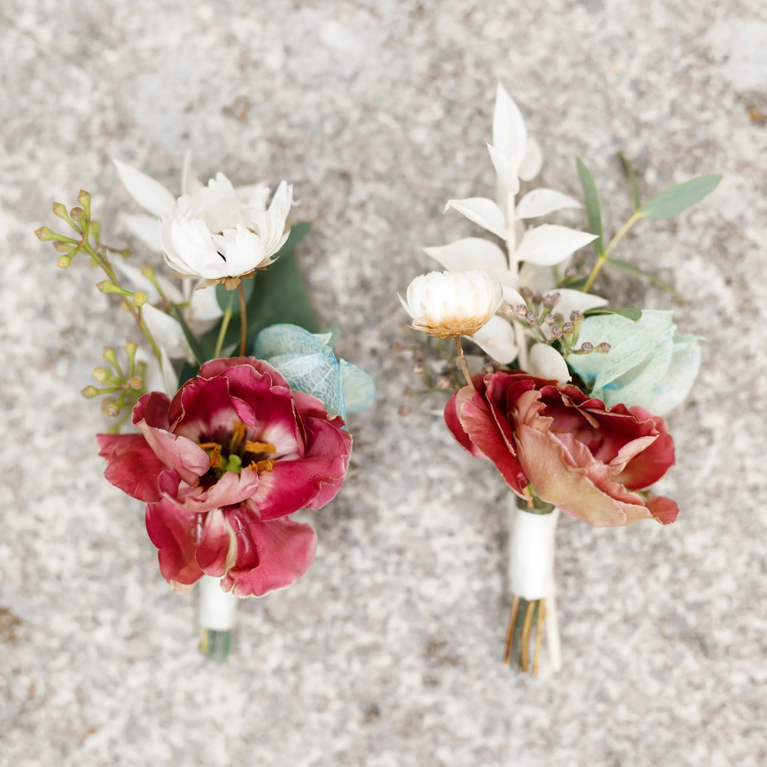 Flat lay of boutonnieres on stone at a Doctor’s House wedding in Kleinburg, Ontario