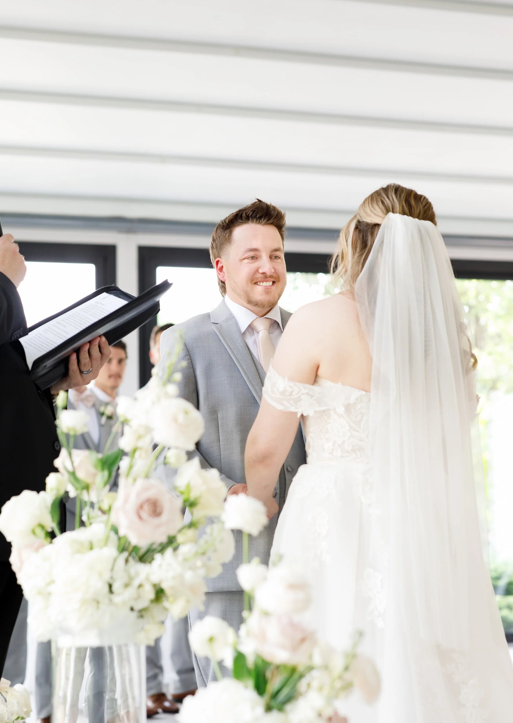 Bride and groom exchanging vows beneath white canopy at Whistle Bear Golf Club in Cambridge, Ontario