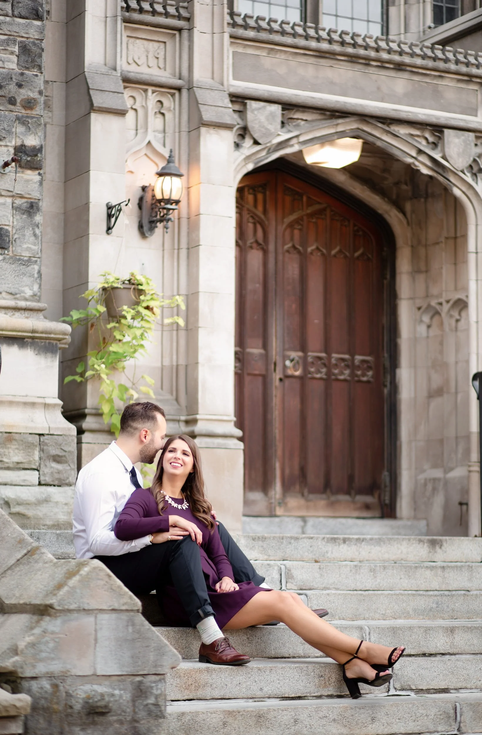Engagement portrait on stone steps outside Knox College at the University of Toronto in Toronto, Ontario