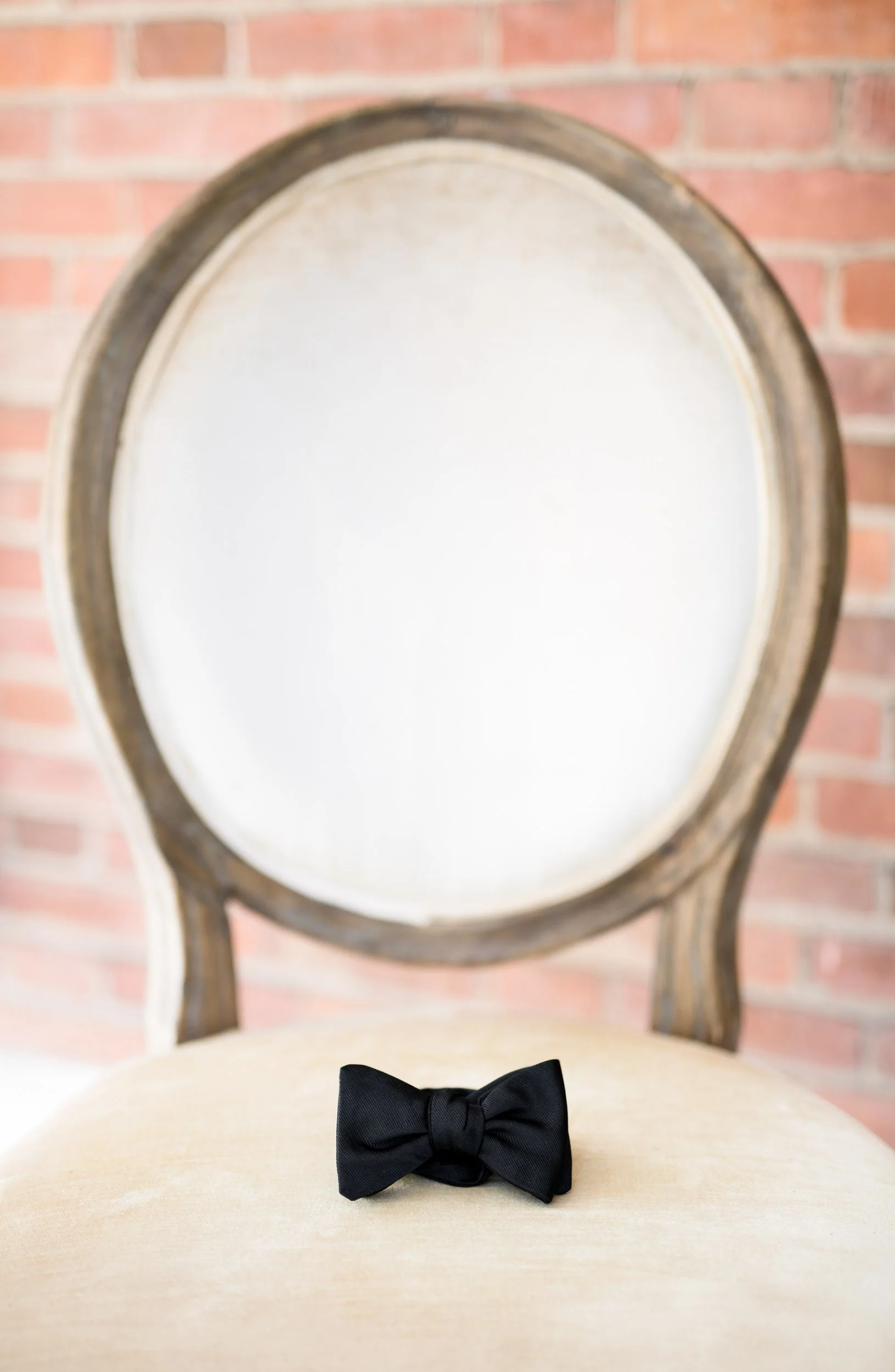 Groom's bow tie wedding detail on ornate chair at Kurtz Orchards wedding in Niagara-on-the-Lake