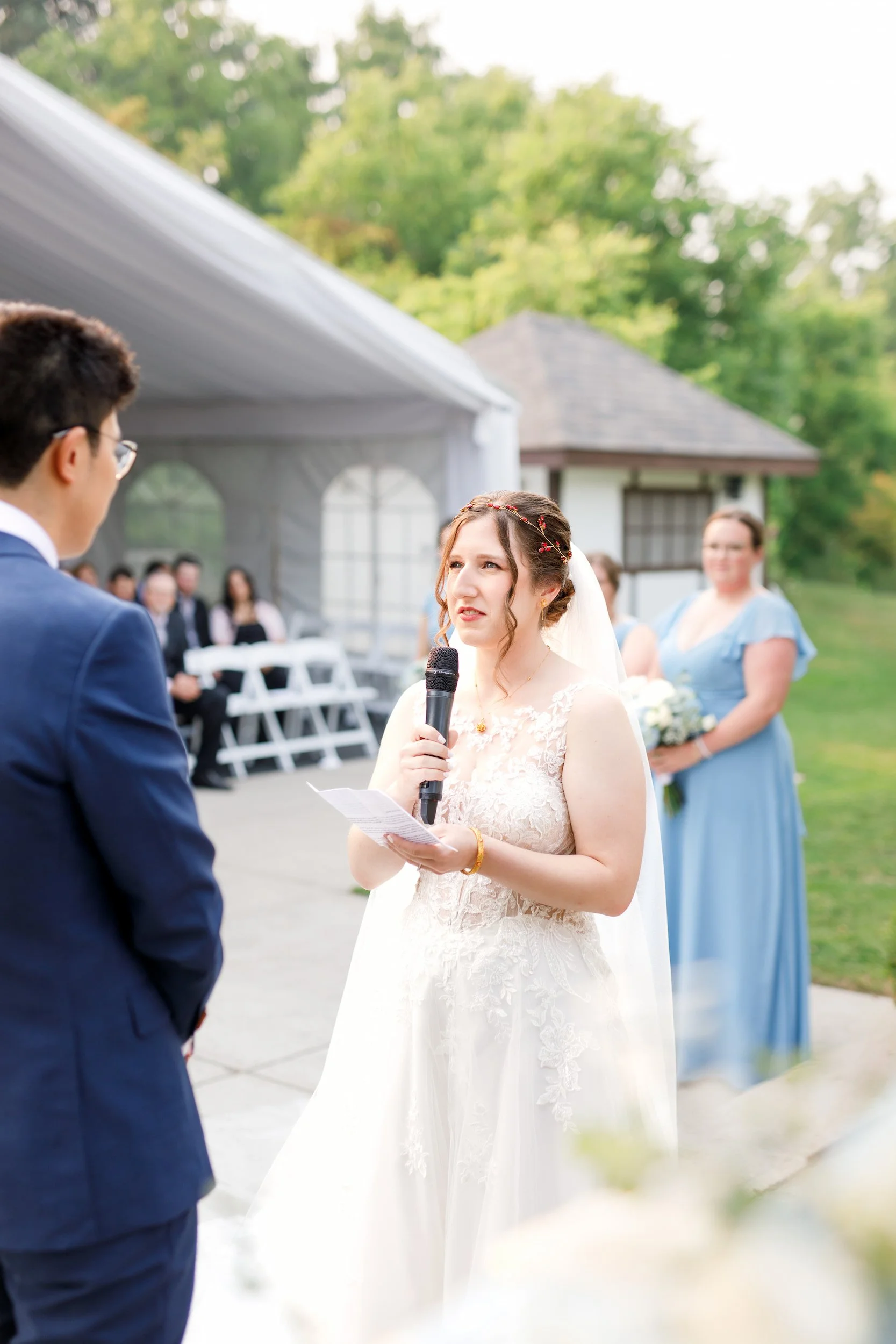 Bride reading vows during outdoor ceremony at The Manor Event Venue wedding in King, Ontario