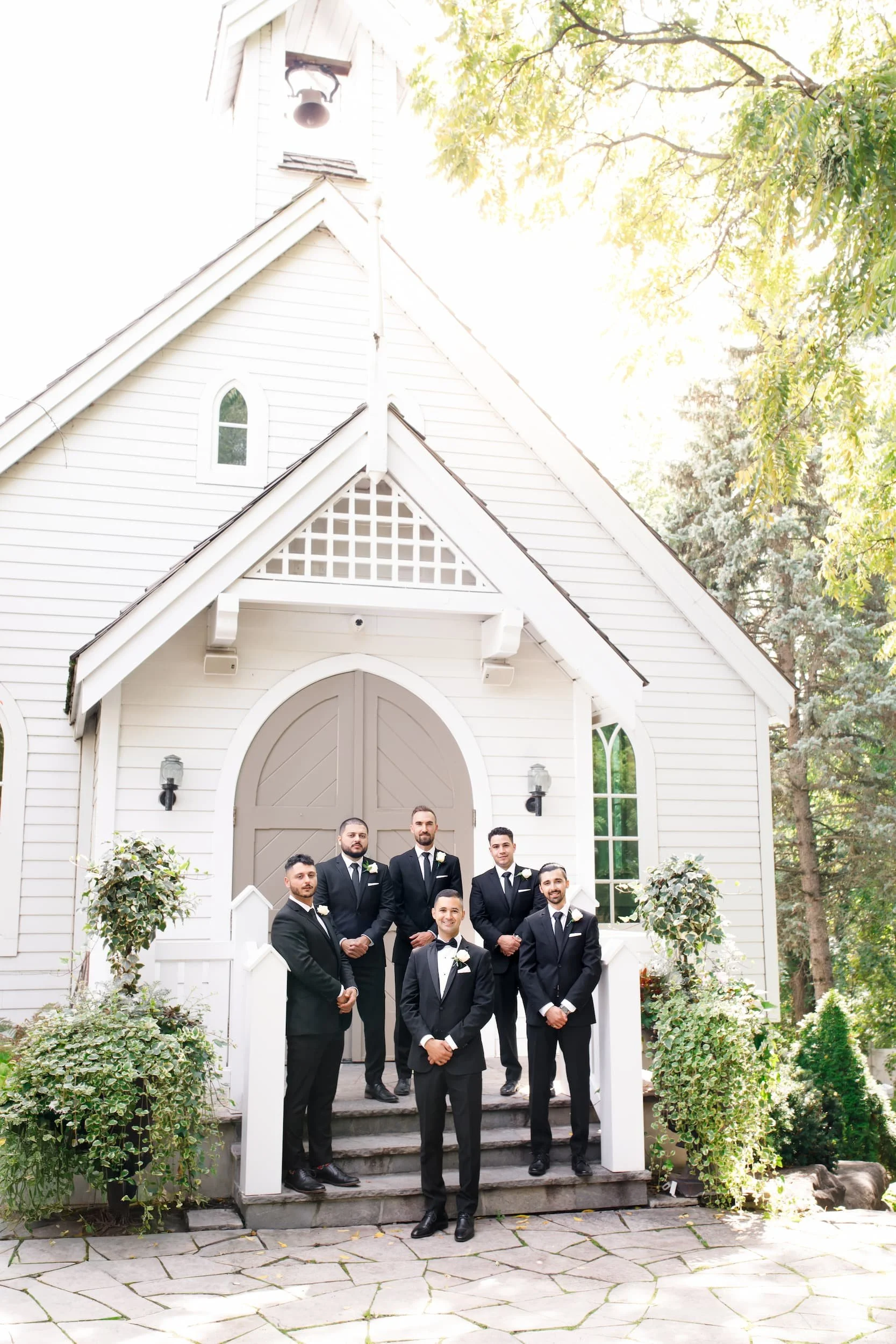 Wedding party outside white chapel at The Doctor’s House in Kleinburg, Ontario