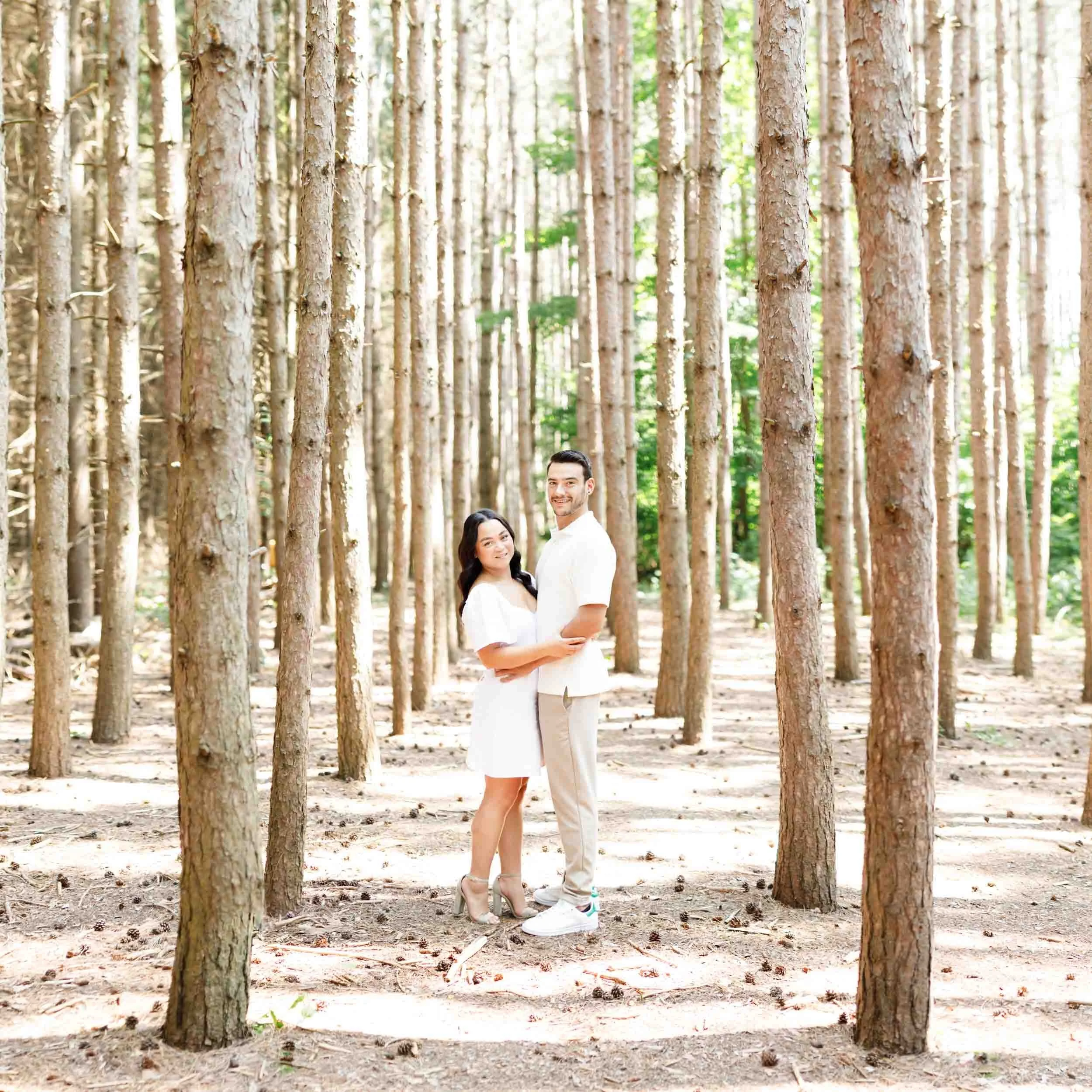 Couple posing among tall trees at Kortright Centre for Conservation in Woodbridge, Ontario