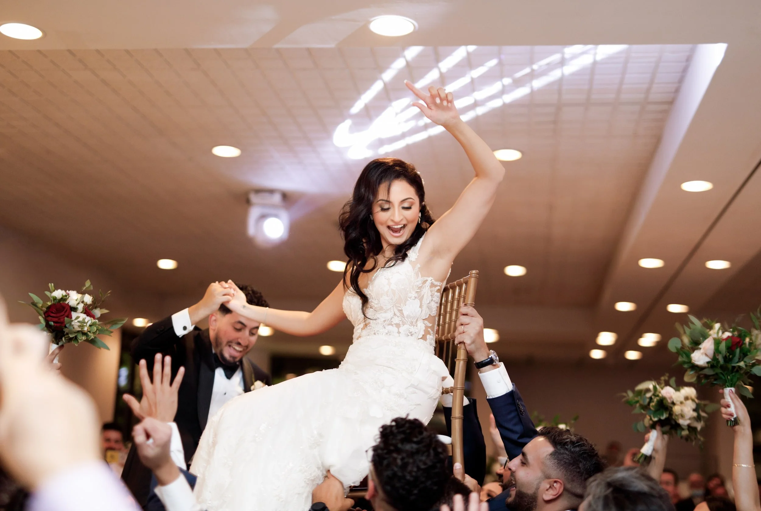 Bride lifted in celebration during lively reception at The Manor Event Venue wedding in King, Ontario