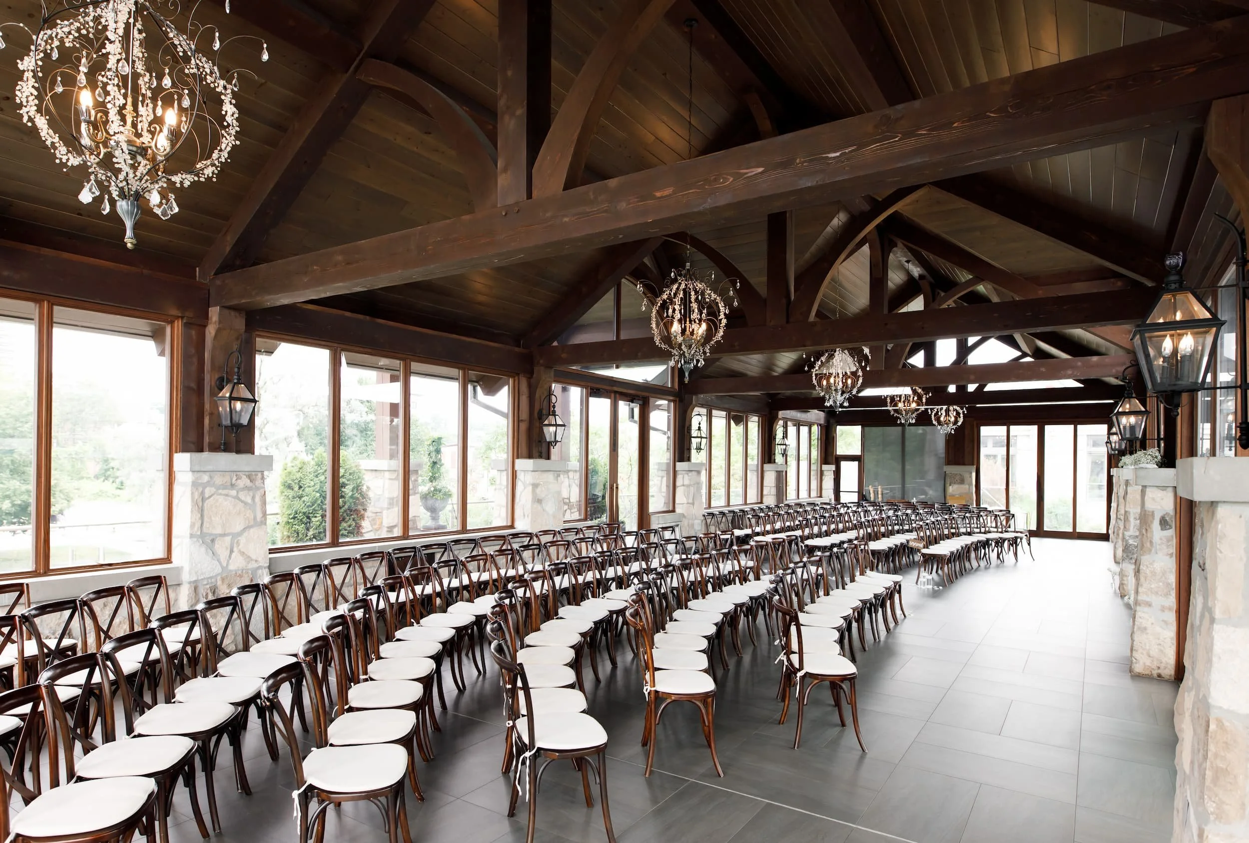 Wide pavilion ceremony layout beneath timber beams at Cambridge Mill wedding