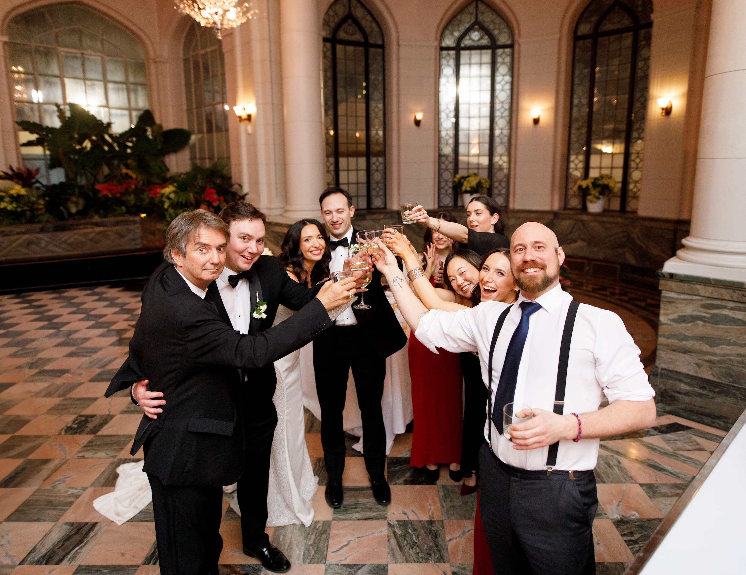 Wedding guests celebrating with champagne inside the Casa Loma Conservatory in Toronto