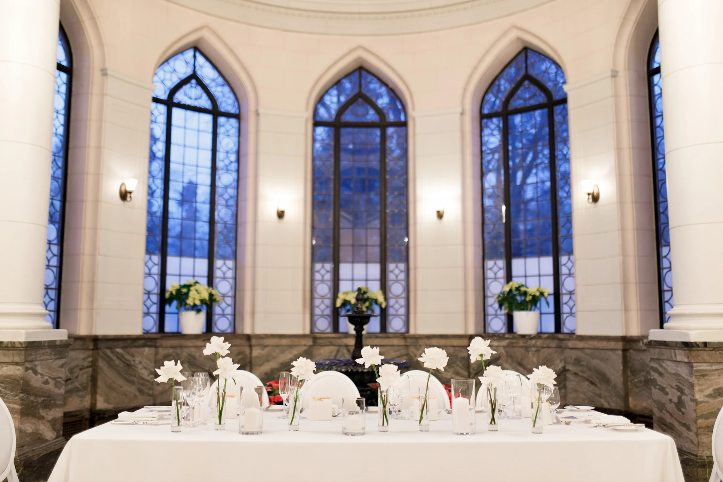 Reception head table with stained glass backdrop at Casa Loma Conservatory